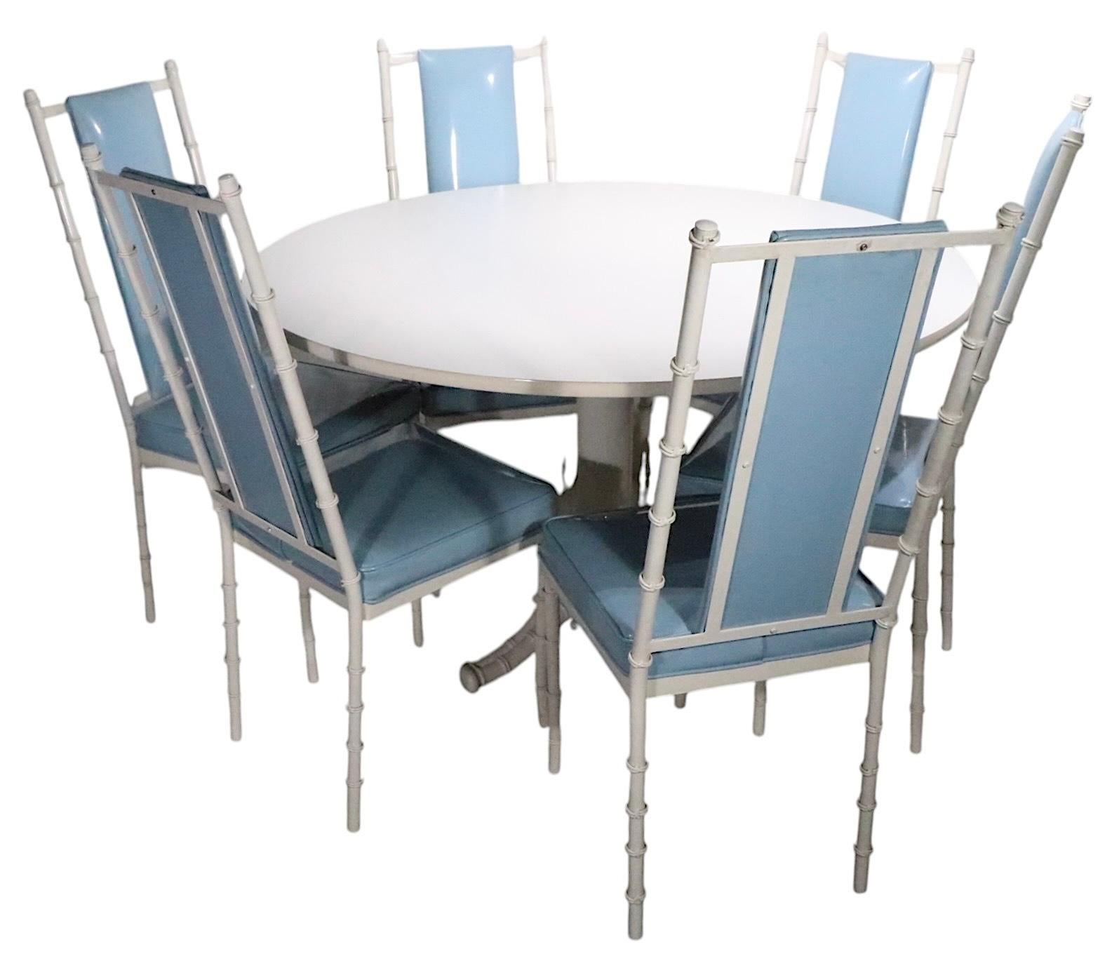 Chic Hollywood Regency, Palm Beach modern style diminutive dining, dinette, kitchen table, having a white laminate top, with cast metal faux bamboo base.
This voguish table, made by Kessler Industries circa 1970’s is in excellent original condition,