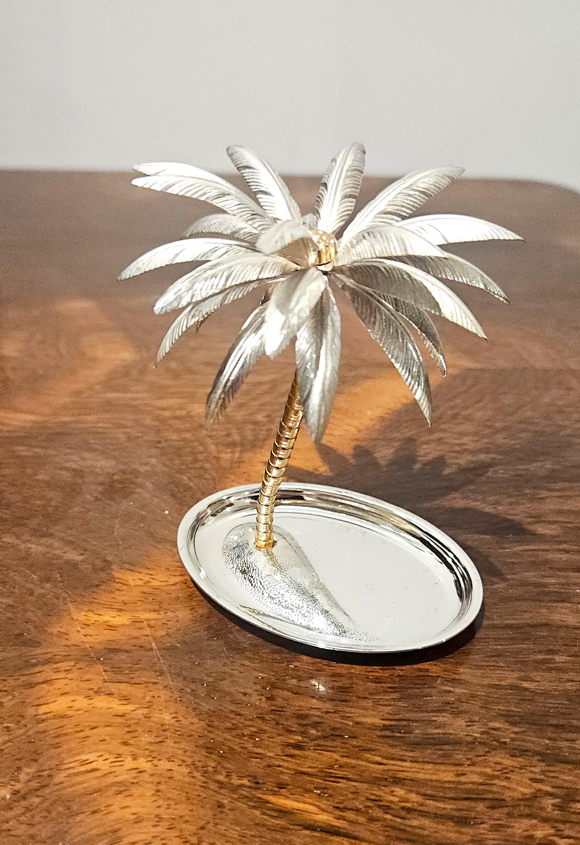 Un plat à bijoux ou à bibelots très décoratif de style Hollywood Regency, représentant un palmier sur une île, en métal argenté et doré, fabriqué en Italie vers 1970.

Le tronc du palmier est finement modelé et présente une finition dorée brillante