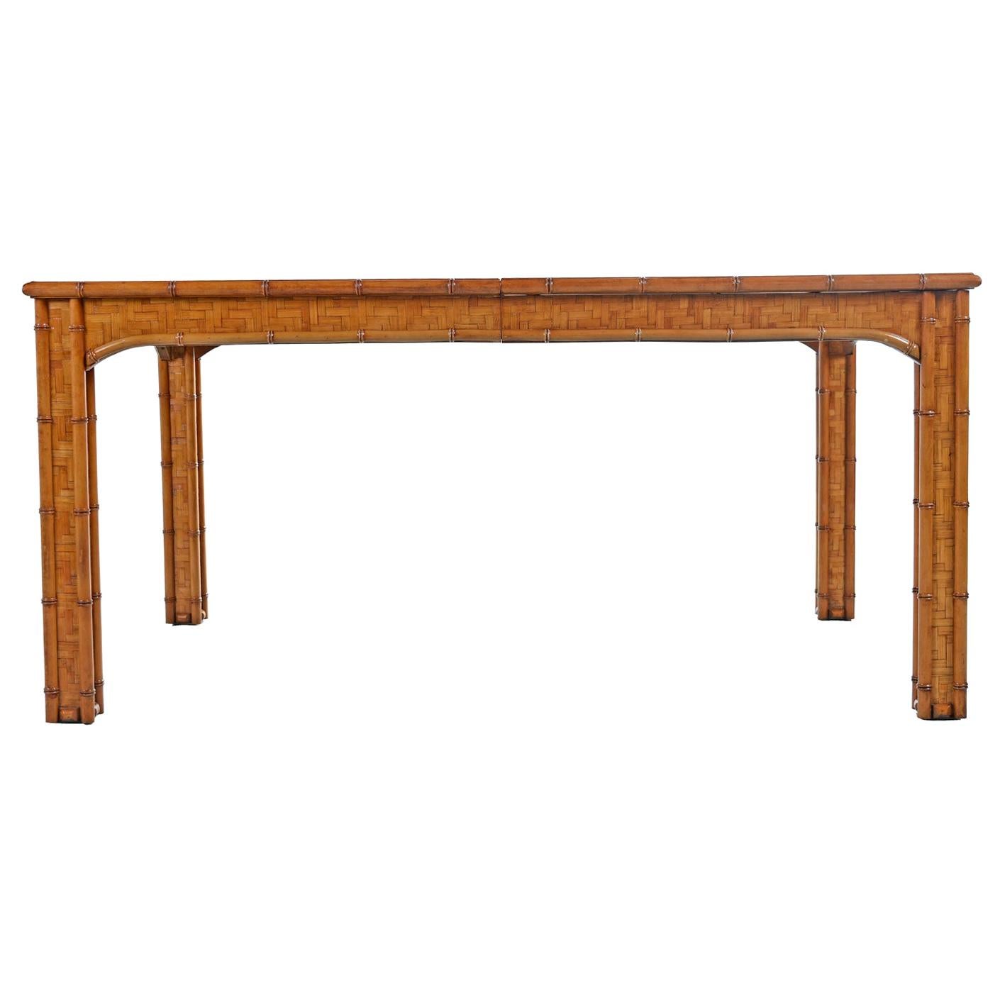 1970s vintage Parsons style dining table or writing desk. Sturdy hardwood construction, completely veneered with a woven rattan basket weave herringbone pattern than looks like parquet. Aged to an absolutely stunning honey amber color. Exceptional