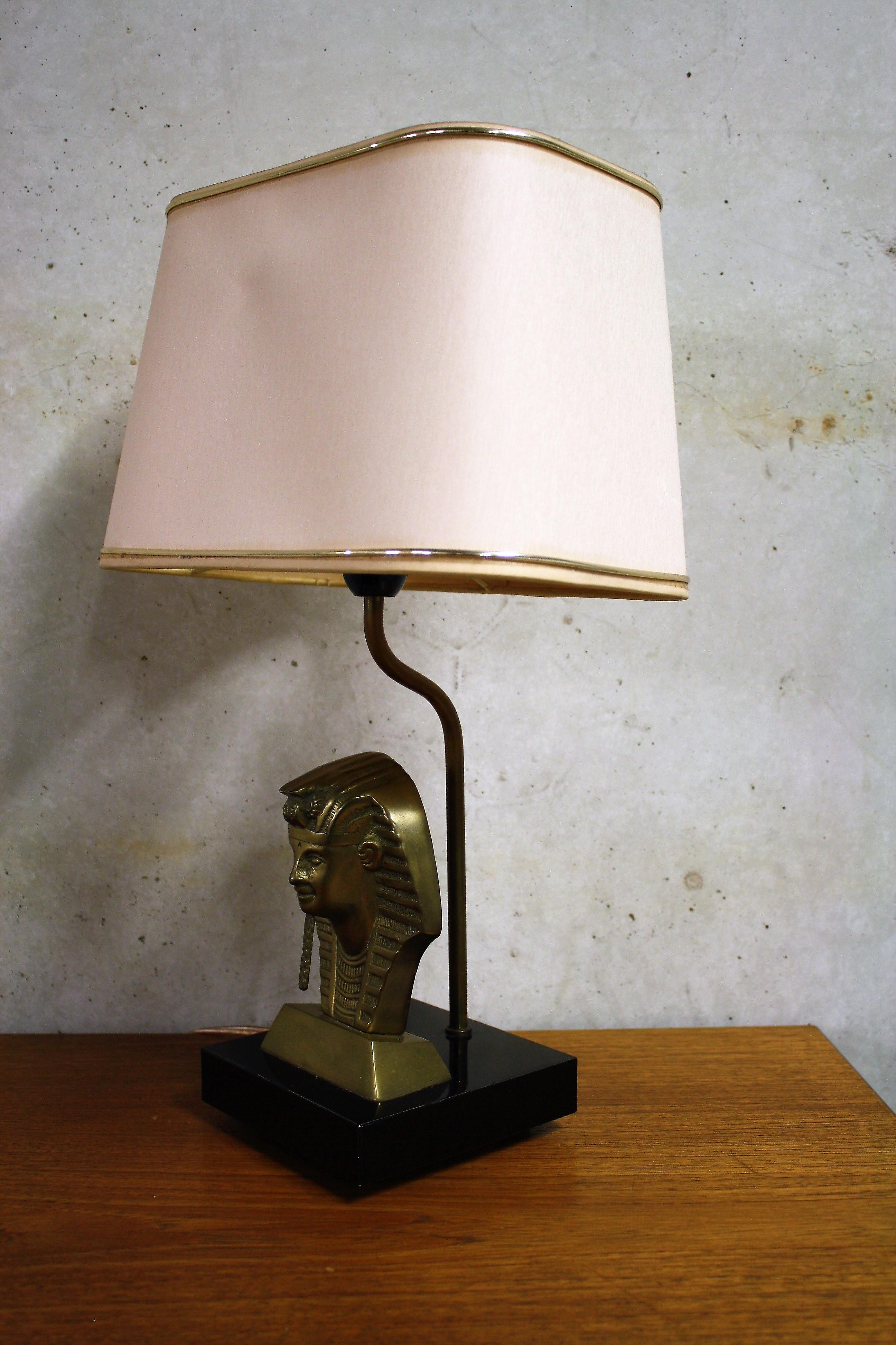 Sculptural pharaoh head table lamp.

The lamp is made from metal on a stone base and comes with it's original shade.

The table lamp emits a warm light and creates a little ambience on it's own.

This Belgian table lamp fits in the popular