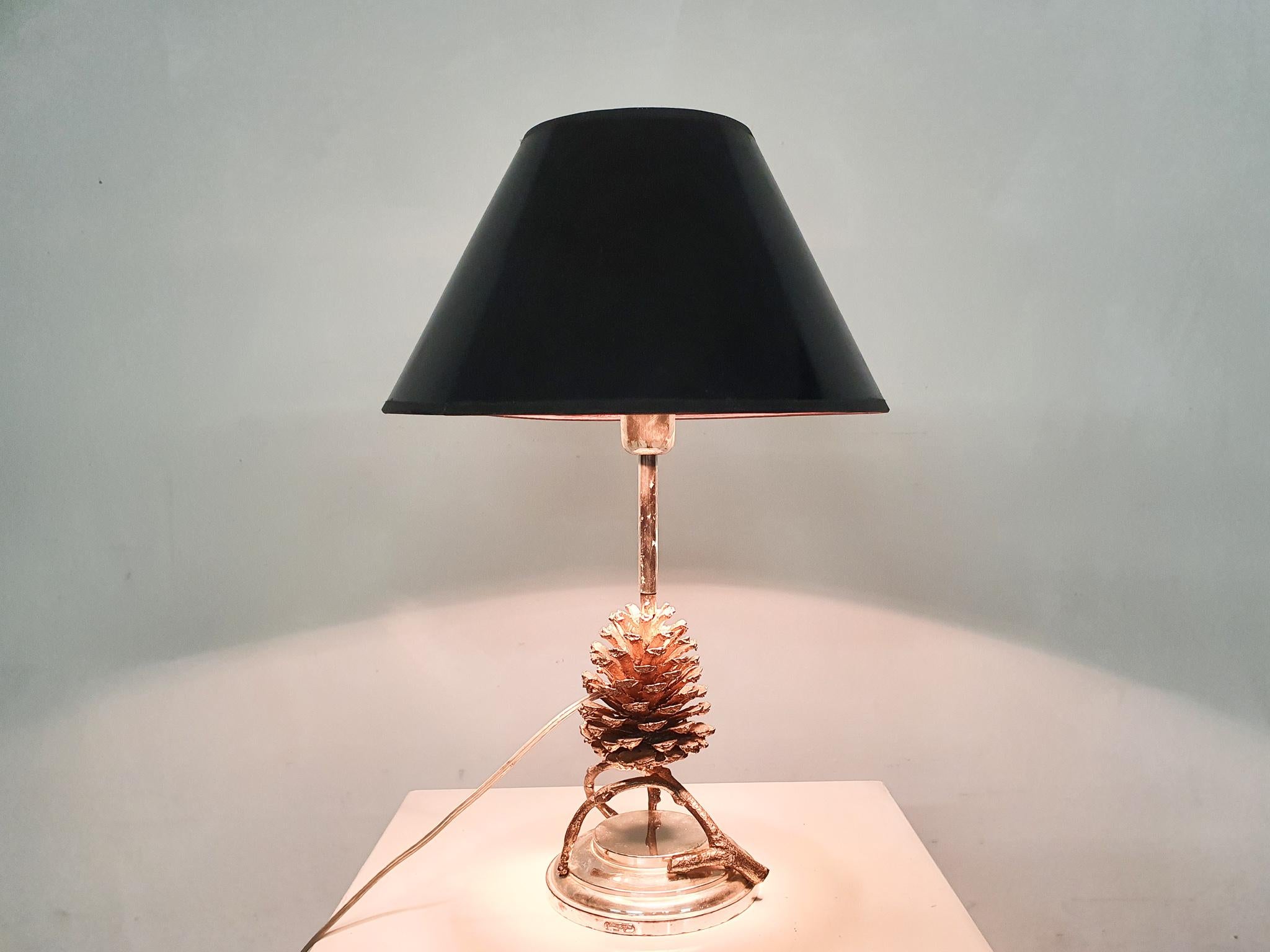 A luxurious, high-quality table lamp, made by Franco Lapini in Italy in the 1970s.

Franco Lapini is a maker of luxury items for the table. Everything is made by hand and is a unique object.

Our lamp is a pine cone made of bronze on a silver-plated