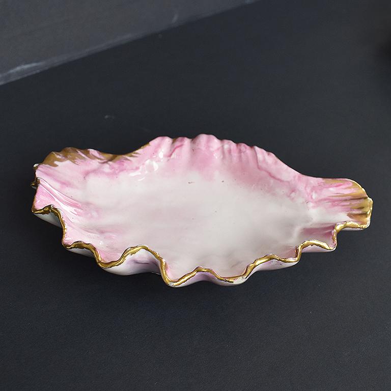 Pink Art Deco style ceramic pearlized clam shell or catch all with gold accented painted rim. A small decorative dish in the shape of a clam shell or oyster shell, with an antique white center and an Ombre pink glaze which moves up the sides. The