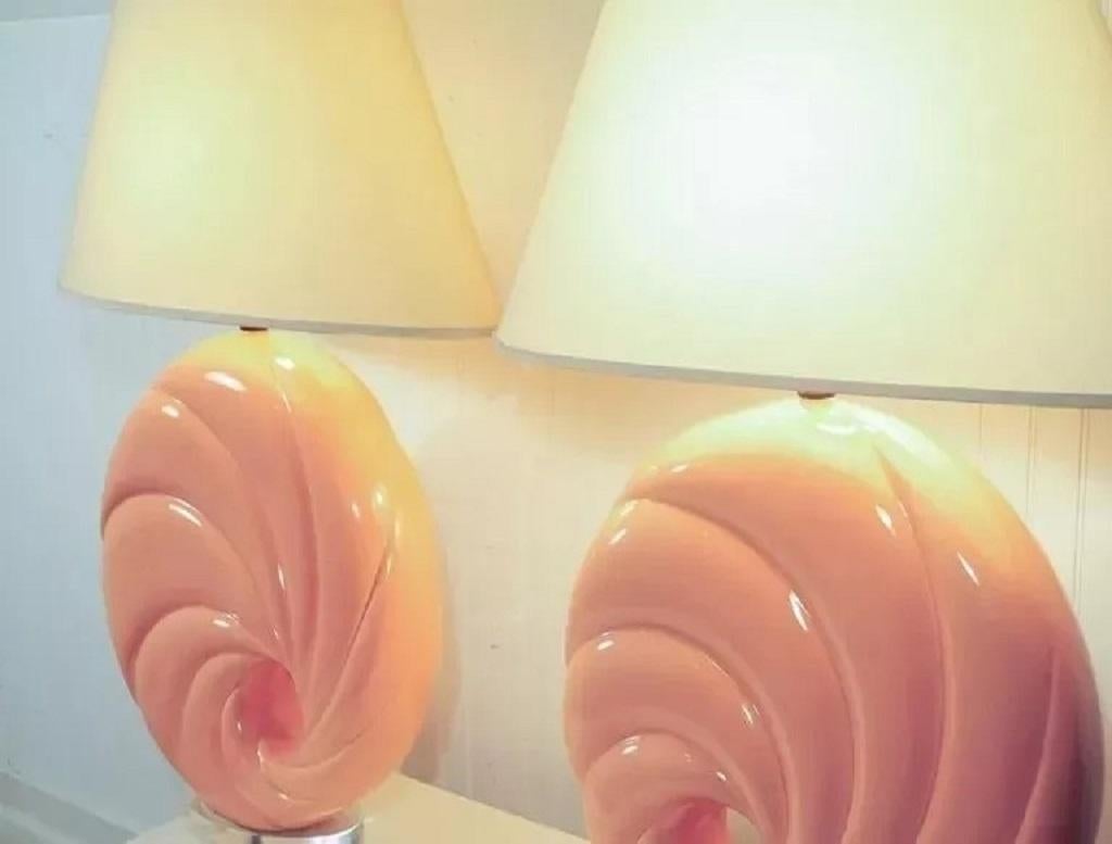 Vintage Hollywood Regency 1980s Pink Swirl Shell Form Ceramic & Lucite Round Table Lamps. This substantial pair of lamps features great decorator form having twisted ceramic bodies with a donut hole through the center. Circa Late 20th Century.