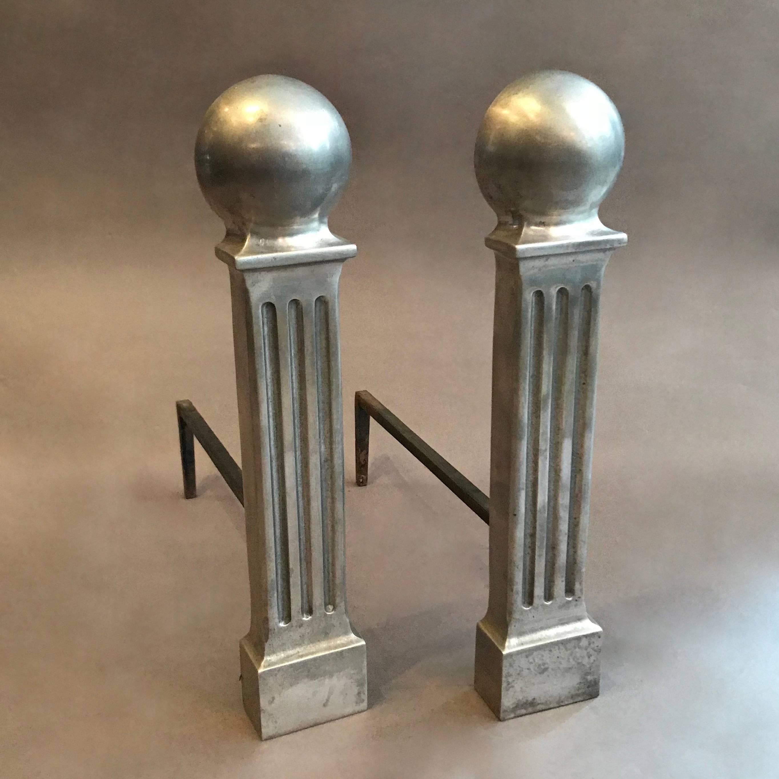Pair of small, Hollywood Regency, fireplace, andirons are polished aluminum in an architectural column motif.