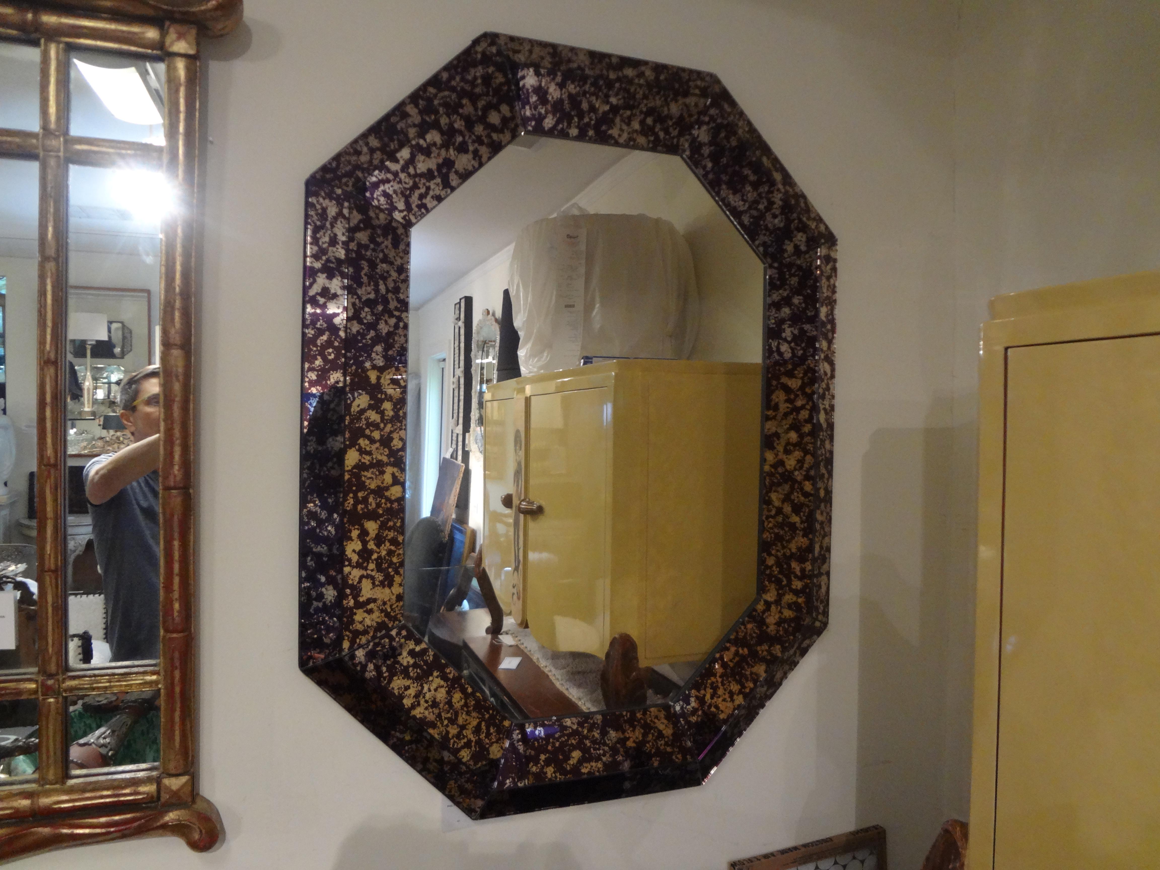 Superbe et inhabituel miroir octogonal violet Hollywood Regency. Ce magnifique miroir du milieu du siècle présente un périmètre de coussin géométrique violet et argenté entourant un miroir central en métal argenté. Peut être affiché verticalement ou