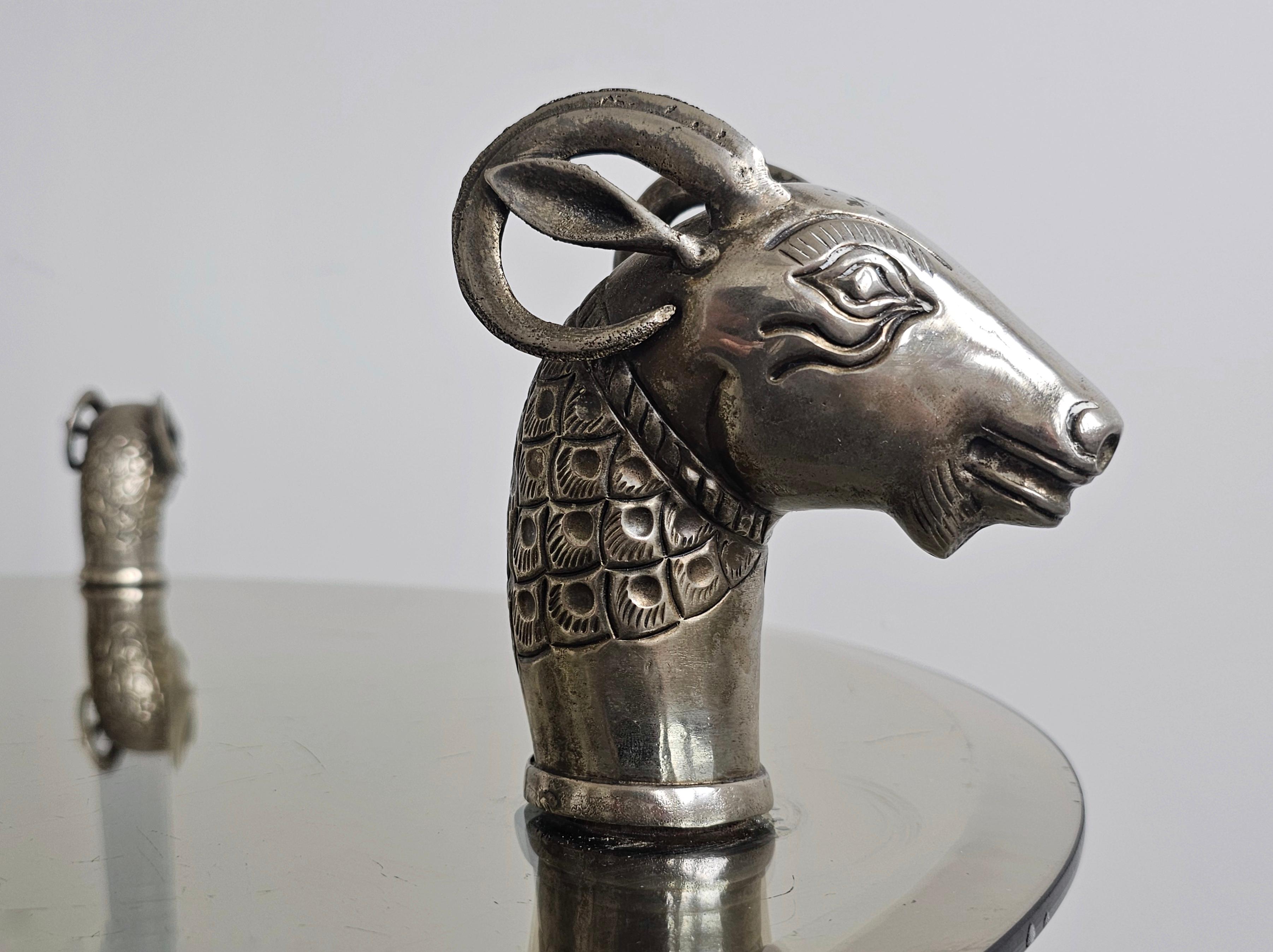 In this listing you will find a spectacular Hollywood Regency coffee or side table done in style of Maison Jansen. It features 3 legs done in nickel plated brass, which end in sculptural rams' heads. The glass top is done in faceted glass and it is
