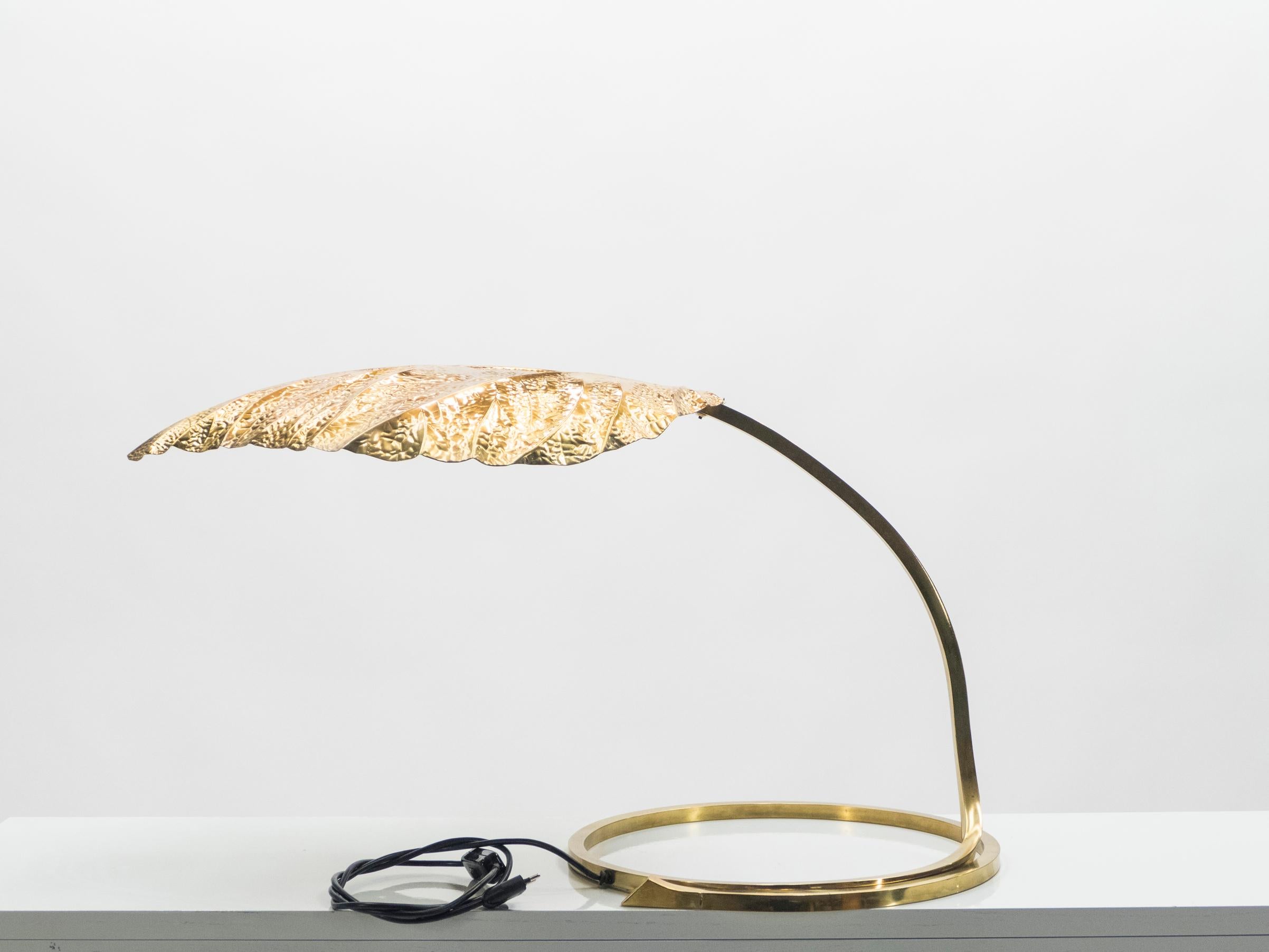 This iconic single leaf Rhubarb table lamp by Tommaso Barbi was produced by Carlo Giorgi in Italy in the 1970s. The circular brass frame sweeps upwards from the base to support the large, decorative, hammered brass leaf. The handcrafted element