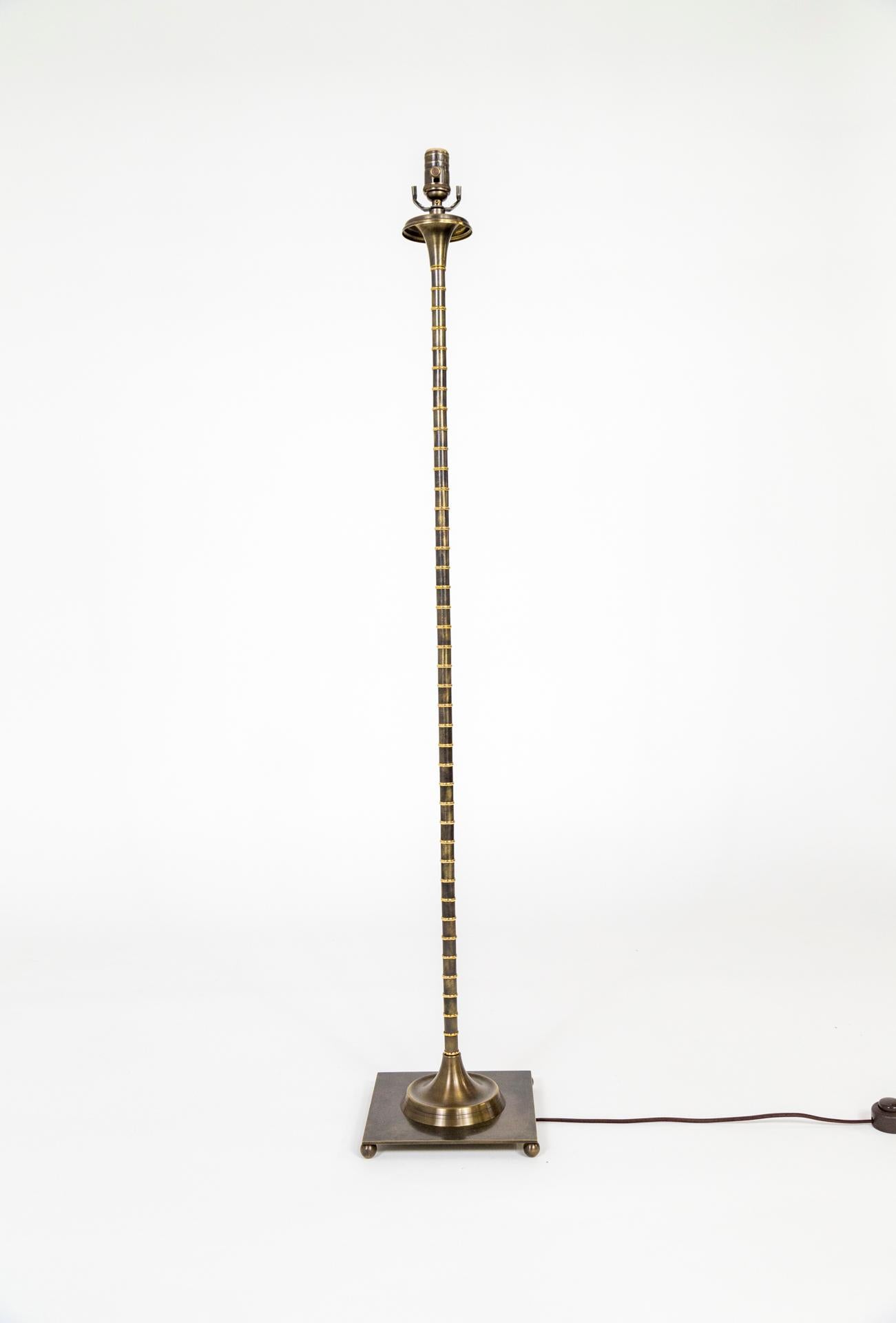 Eine Stehlampe aus massivem Messing im Hollywood-Regency-Stil, gerippt für eine Bambusoptik. Mit handgeriebenem Bronze-Finish variiert mit messingfarbenen, geriffelten Details und subtilen Kugelfüßen unter einem quadratischen Sockel. Amerikanisch,