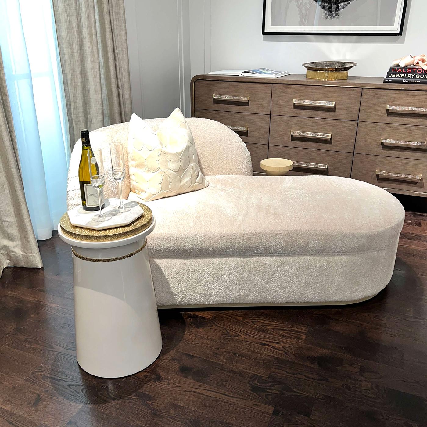 A sculptural gem that pairs bold geometry with glamorous details. A sleek, conical base finished in crisp lacquer provides a modern foundation for the organic beauty of a polished brass top. A coordinating brass trim wraps just beneath the flared