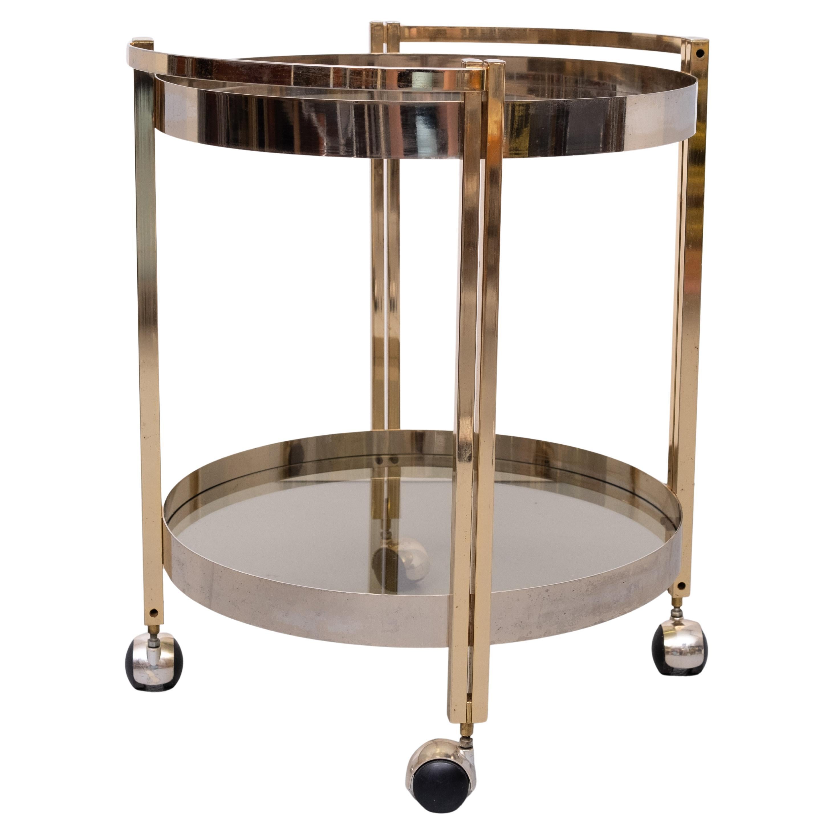 Very nice serving Trolley .on wheels Round shaped .Smoked Glass
Brass and Nickel . Good quality piece .

Please ask for cheaper shipment solutions . 
