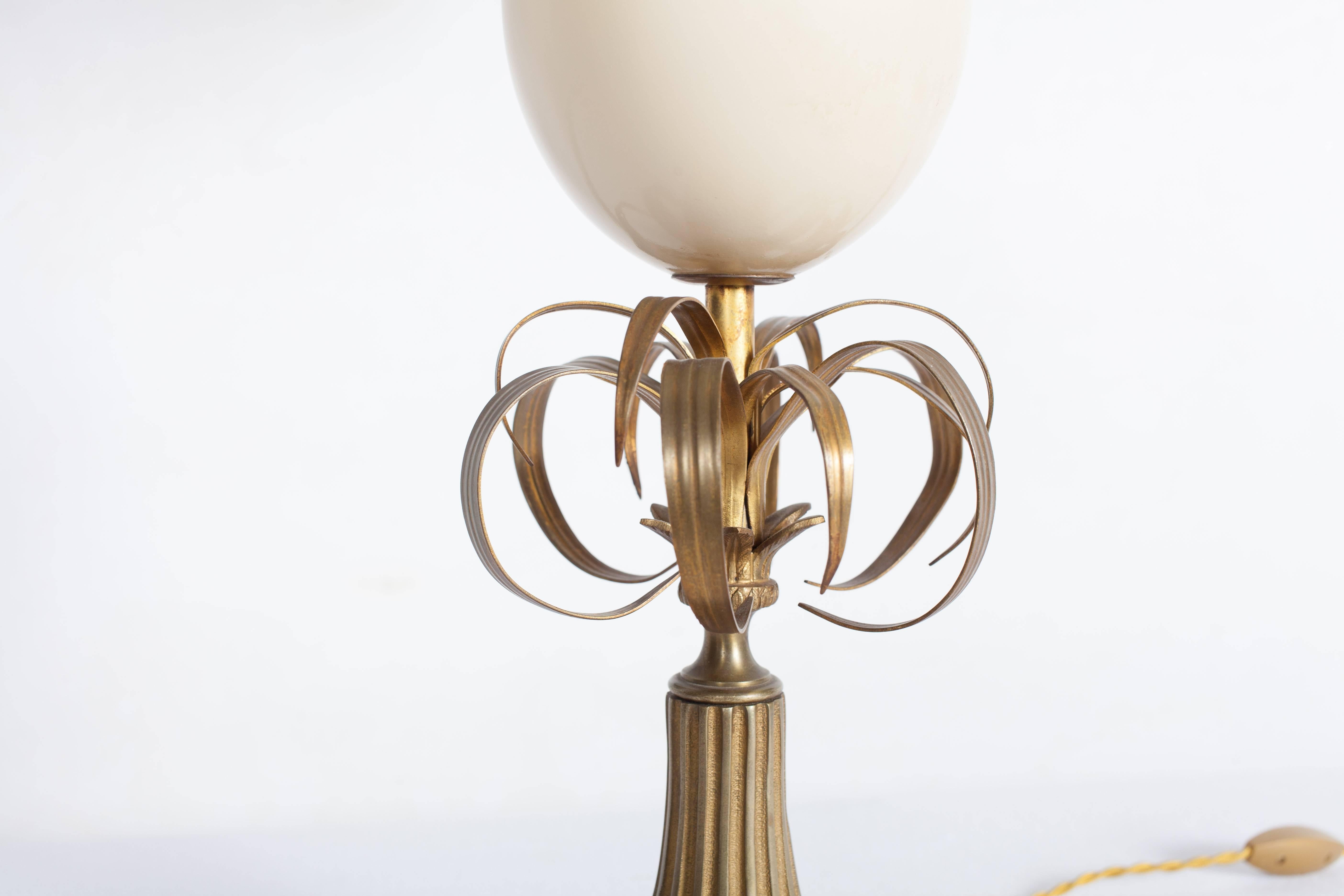 Maison Jansen decorative table lamp.
An ostrich egg with brass leaves gives this a palm tree lamp effect.
France, 1970.
Would fit well in an eclectic Hollywood Regency inspired interior.

    