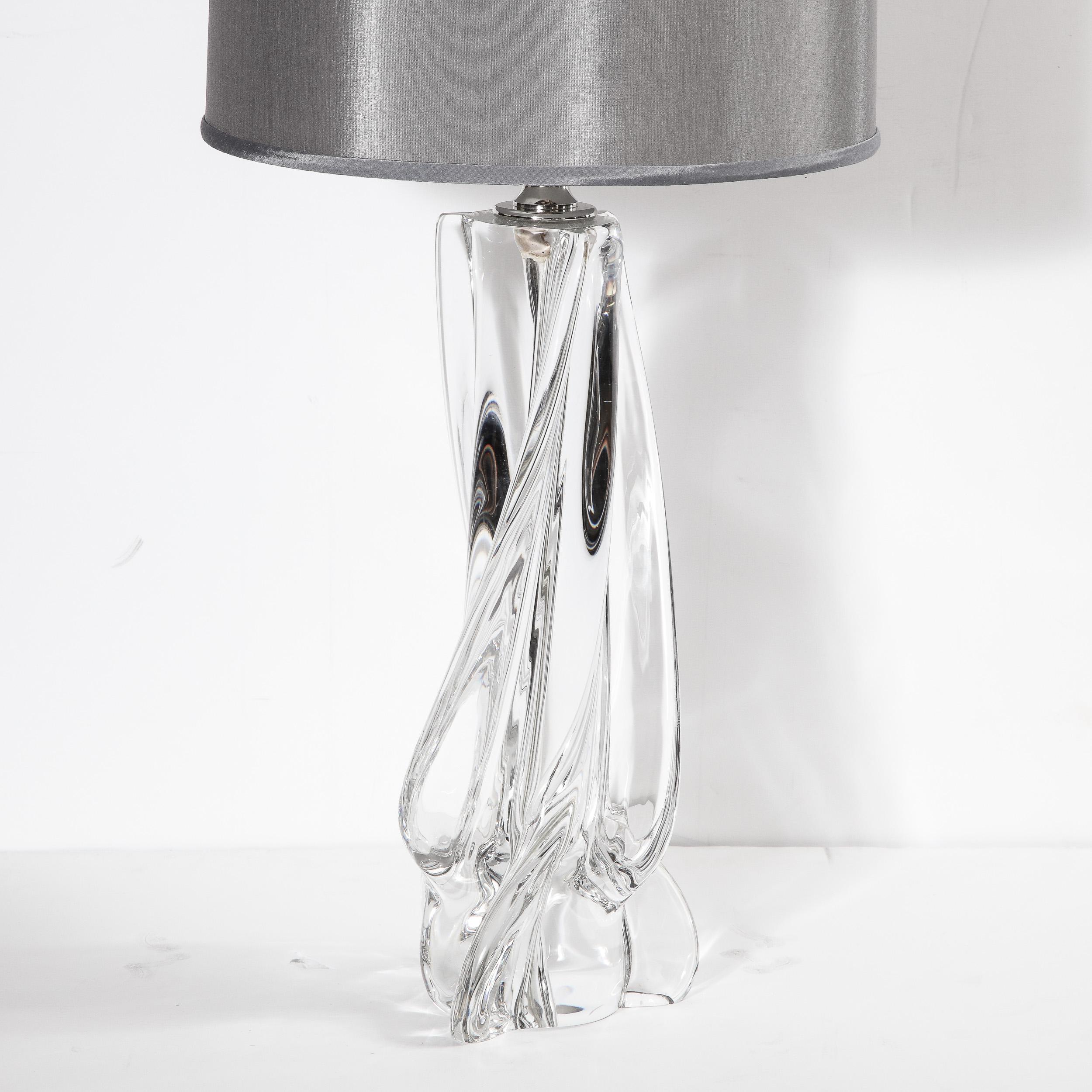 This elegant Hollywood Regency sculptural crystal table lamp was realized by the fabled French maker Cristalleries De Sevres, circa 1945. It features a sculptural translucent glass body full of sinuous curves. With its clean modernist lines and