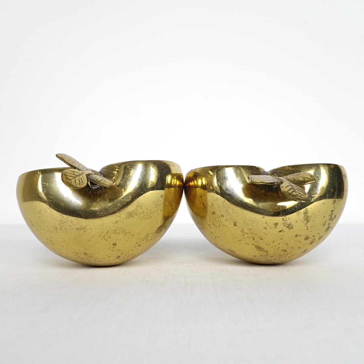 Attractive set of two shiny brass apple parts that make perfect bookends due to their impressive weight as they are filled with sand. Marked 