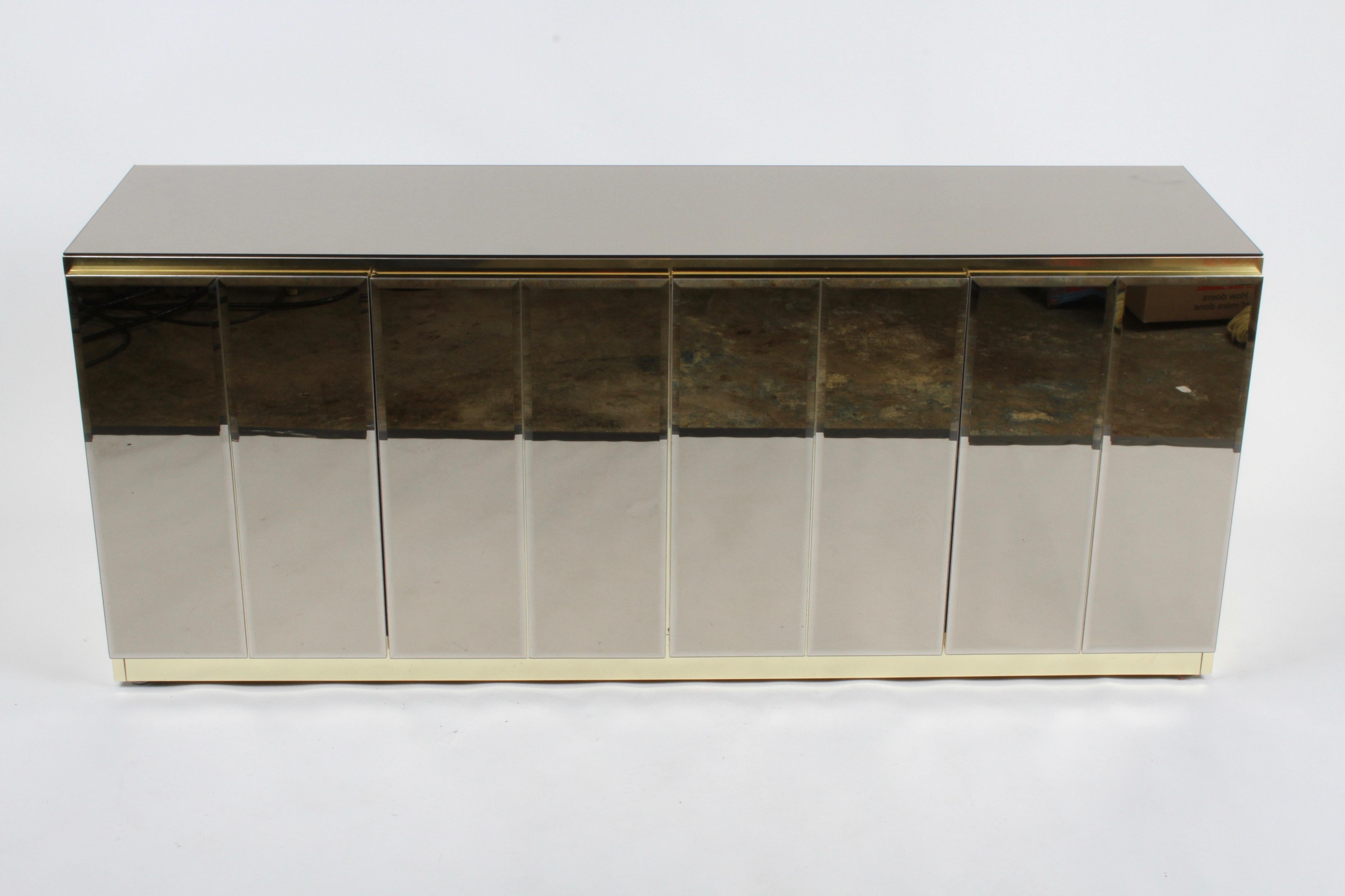 Fabulous Hollywood Regency signed Ello sideboard /buffet with bronze mirror top, bronze beveled glass doors and brass detailing. The interior having adjustable shelving and a single drawer. Shelves are 35