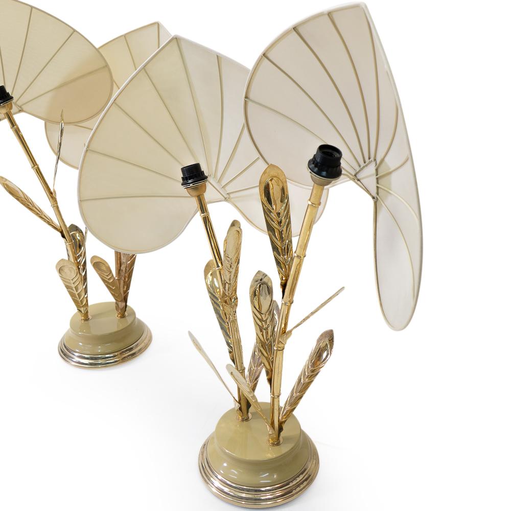 Italian-made table Lamps by Antonia Pavia, with brass bamboo-shaped stem, thin metal leaves, and silk screen palm shaped shades.

A beautiful example of the 1970s Hollywood Regency style.

The shades can be rotated, to ensure that no direct