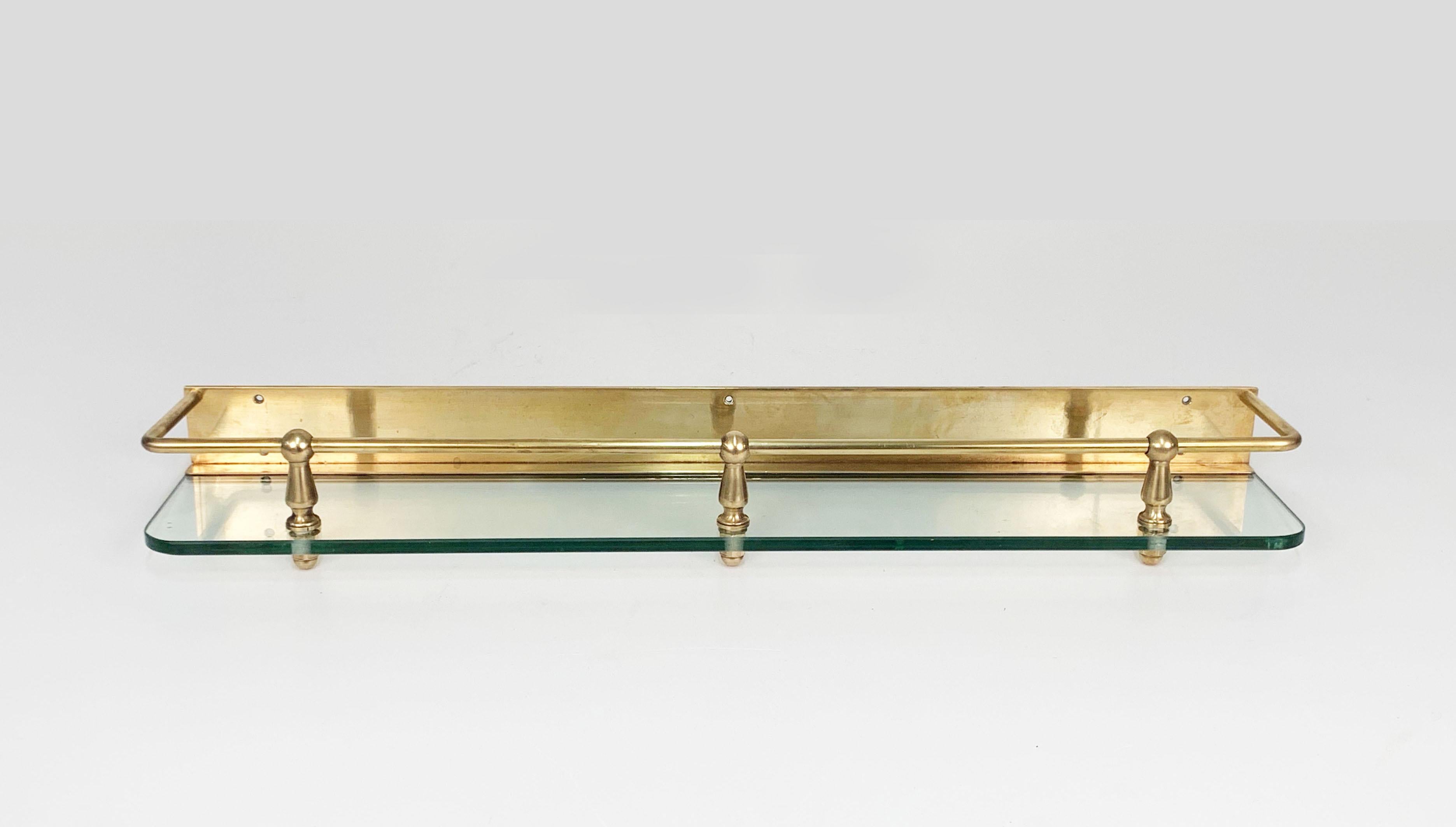 Wonderful solid brass and crystal glass wall shelf. 

Great design and lines both for the glass and the brass parts, that are kept together by three iconic Hollywood Regency style elements.

There are four pieces available, that will give light