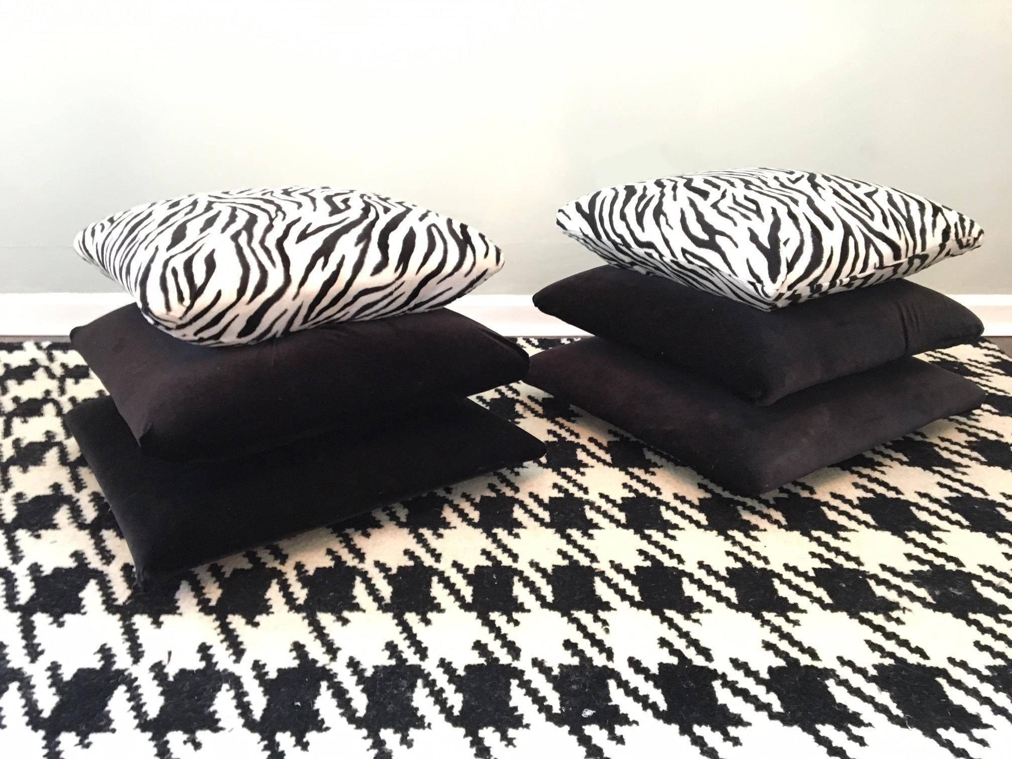 Perfect for your Hollywood Regency décor, this pair of footstools features a design that mimics stacked pillows in black with a zebra print pillow on top. Very heavy and sturdy, they are made of a solid wood frame upholstered in soft velvet with