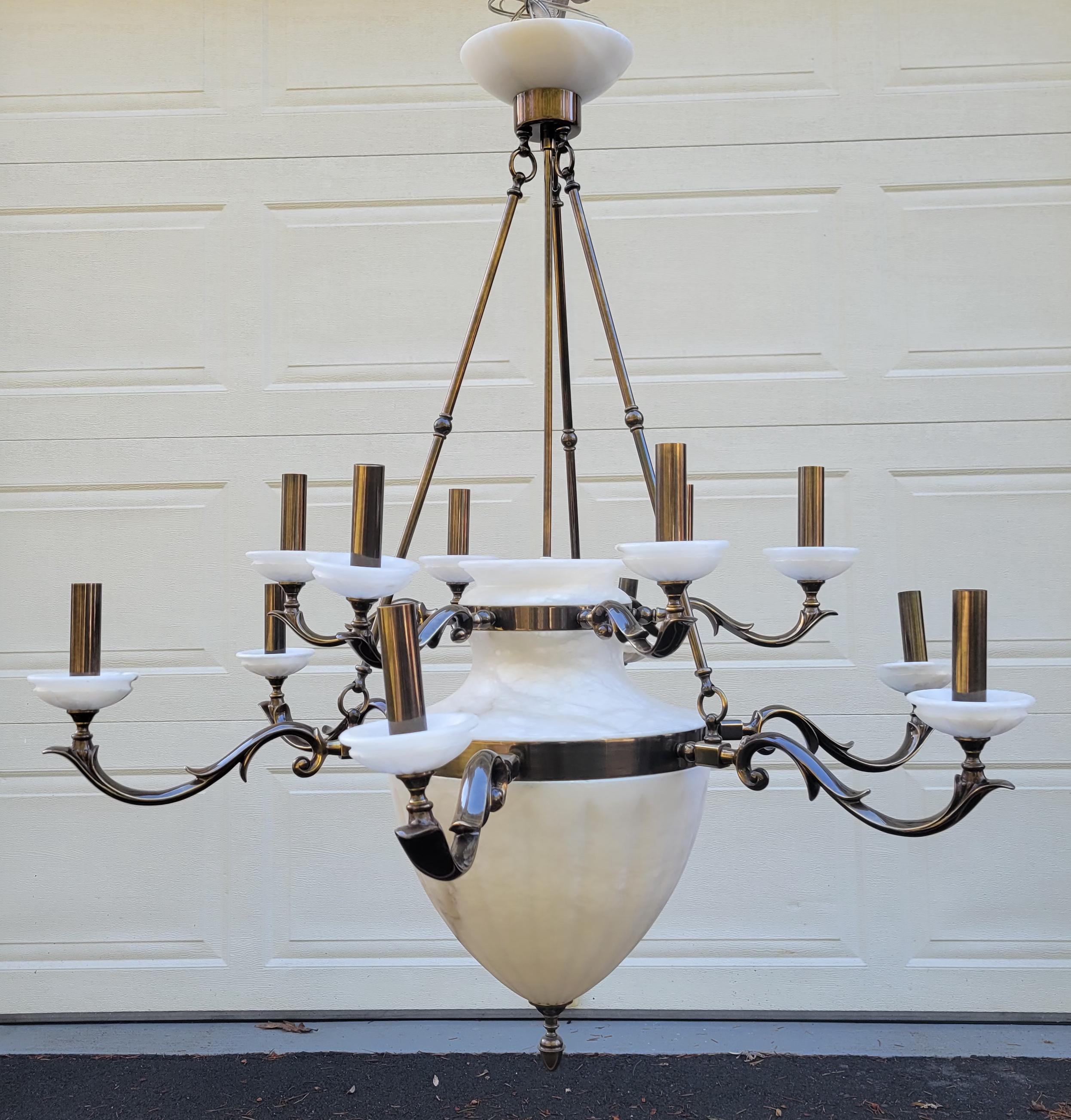 Hollywood Regency Style Alabaster Silver 12 Light Chandelier. Alabaster fluted vase shaped dome with twelve flowing silver scrolled arms, each with an alabaster boboche and silver light covers.
