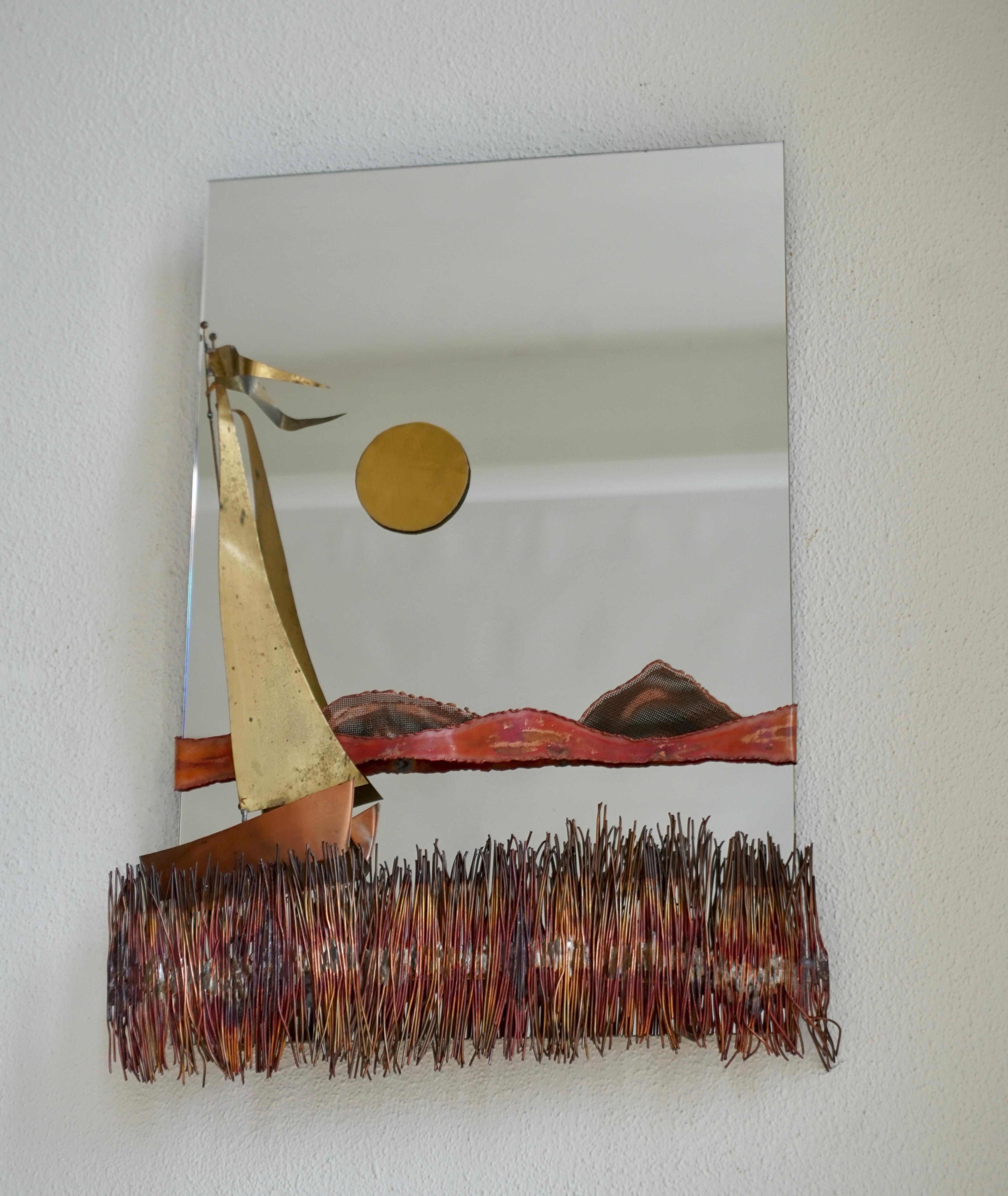 Hollywood Regency Style And 1970s Copper And Brass Wall Mounted Sculpture Mirror made by Daniel d'Haeseleer, Belgium, 1970. This eyecatcher piece is made of brass and copper details. This scultpure mirror is showing a sailboot and poetic sunset over