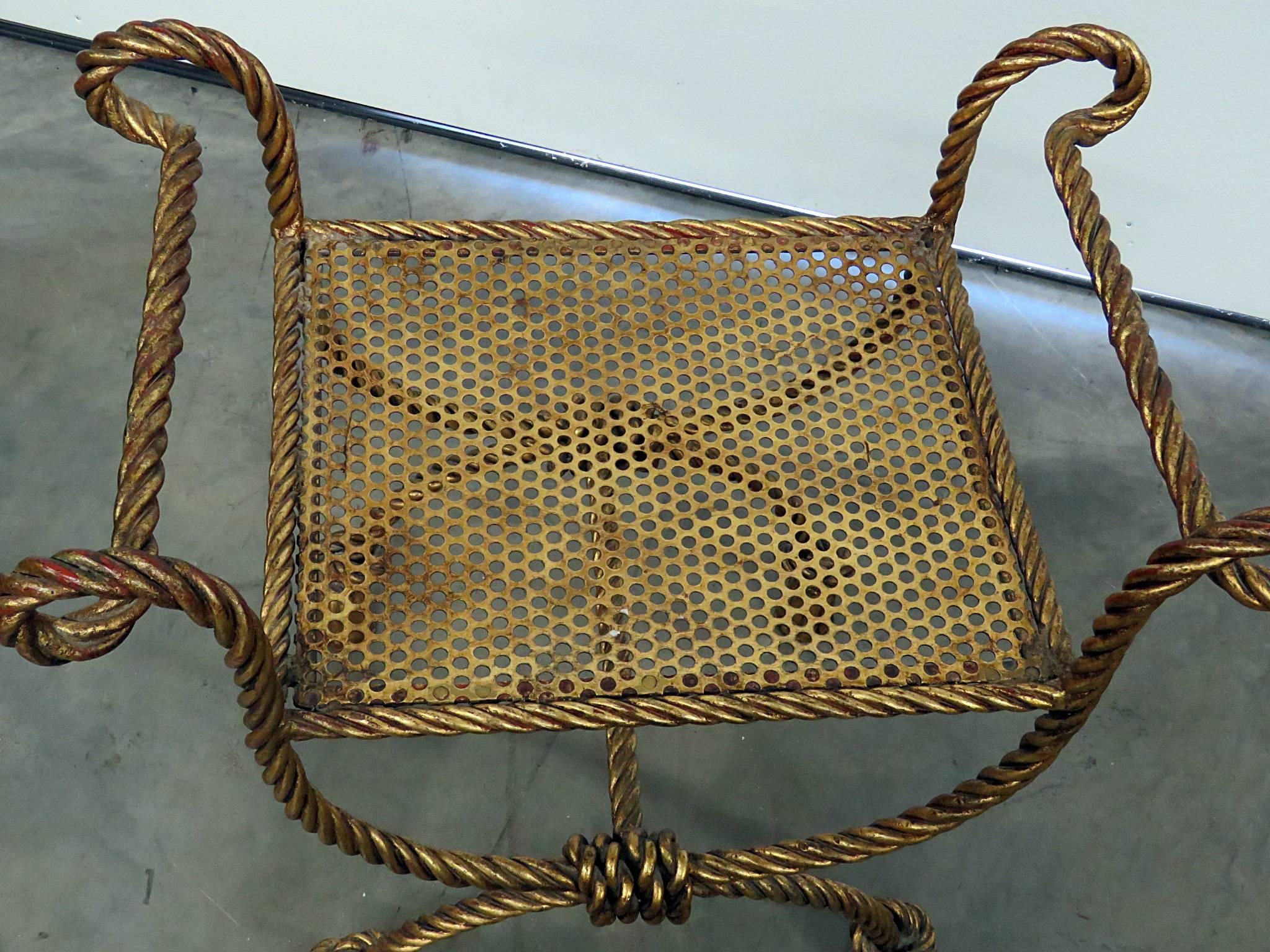 Hollywood Regency style bench. Gilded metal with a rope twist and tassle design. Measures: 19