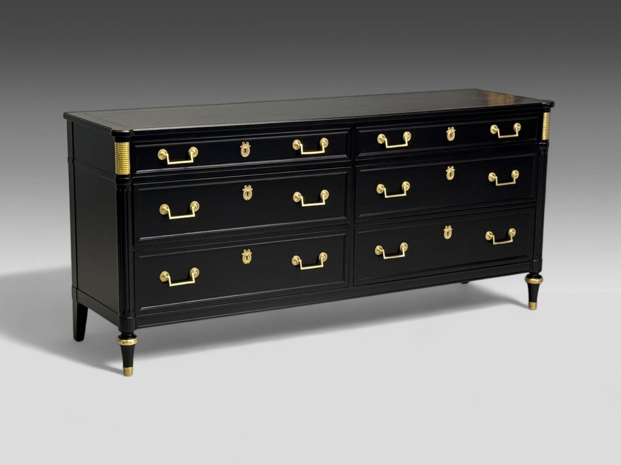 Stile Hollywood Regency, lacca nera, bronzo, cassettone, USA, anni '60

Un comò a nove cassetti in stile Maison Jansen completamente rifinito in lacca nera satinata, con tiretti rettangolari in bronzo e montature in bronzo Directoire a forma di