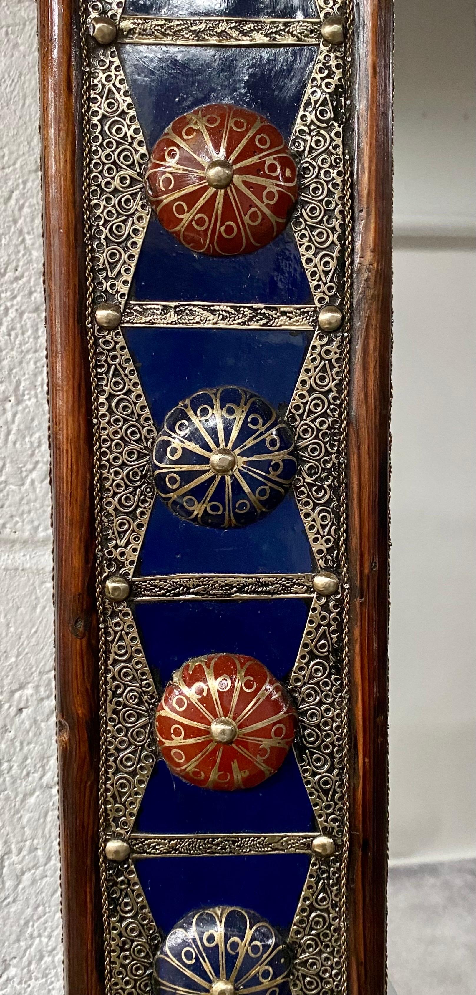 A majestic handcrafted Hollywood Regency style with Moorish flair mirror made of wood and painted in cobalt blue with bronze inlay and embellished with natural stones in blue and red. The handmade mirror is a wonderful creation by master artisans in