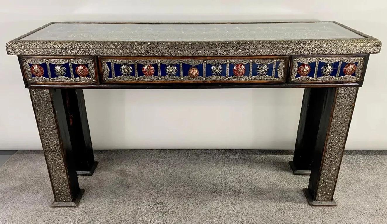 Behold the majestic allure of a handcrafted Hollywood Regency style console, intricately designed with a touch of Moorish flair. Crafted from wood painted in a resplendent shade of cobalt blue, this exceptional piece is adorned with the finest