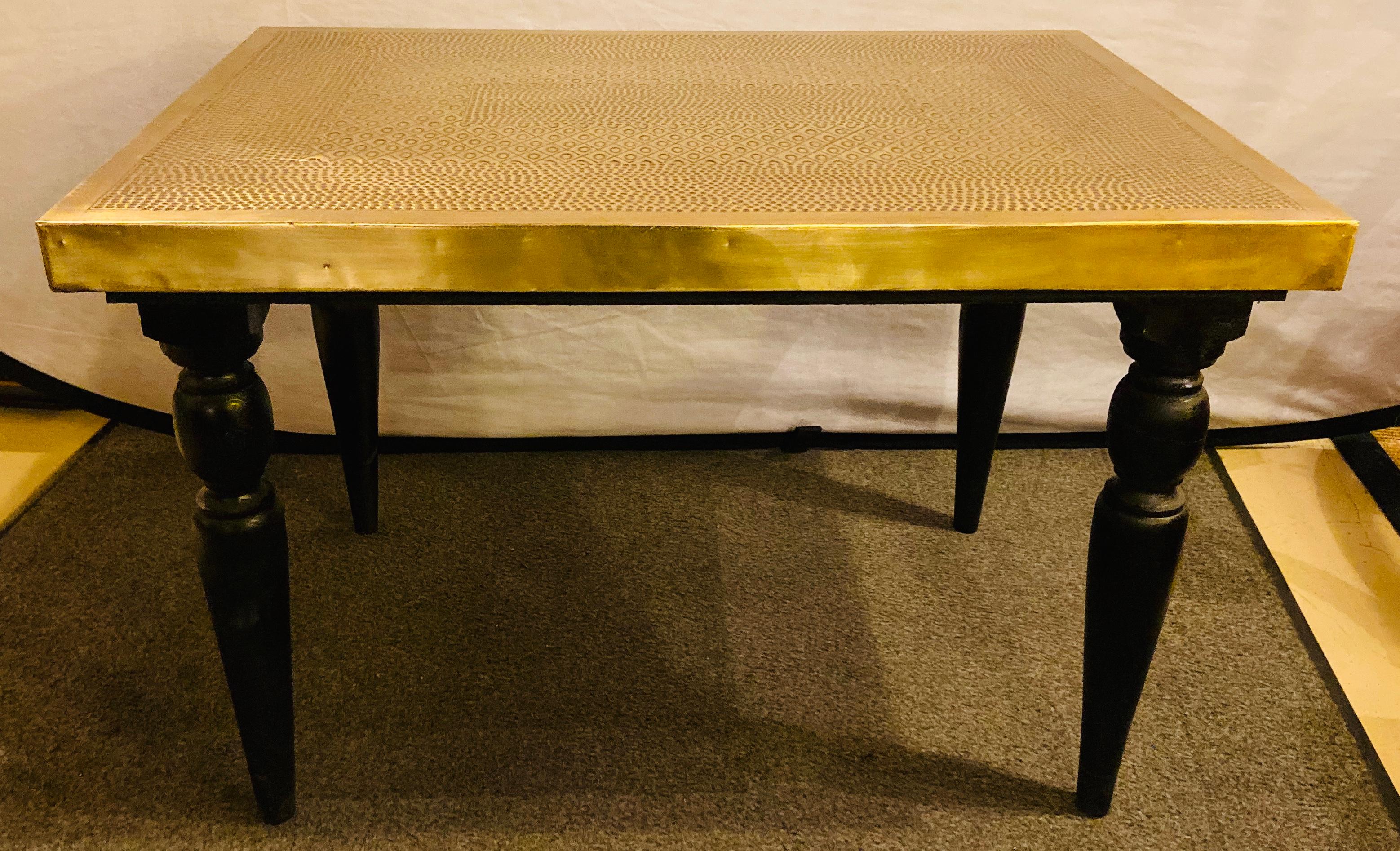 A pair of  Hollywood Regency style hand-crafted brass center or end tables. These tables exude a timeless charm, boasting sleek rectangular silhouettes adorned with fine hammered designs upon their lustrous gold brass tops. The allure extends