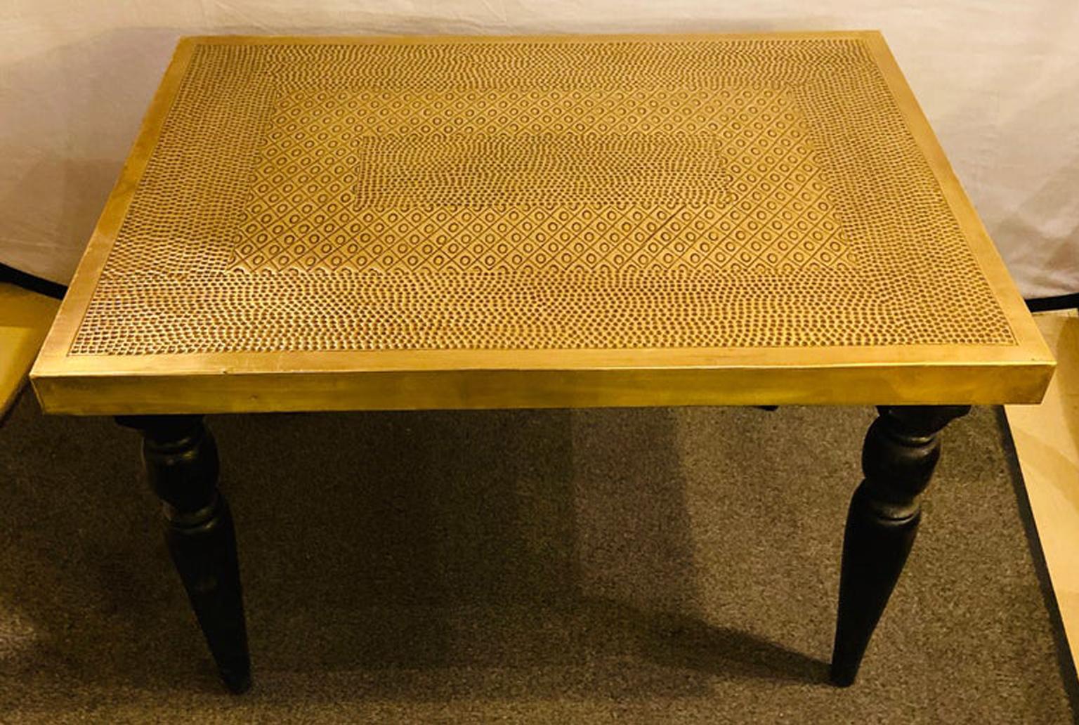 Hollywood Regency style brass center or end table

A chic and very stylish Hollywood Regency brass rectangular table. The table features a fine handmade hammered design on the all gold brass top. The legs made of ebonized wood are nicely carved.
