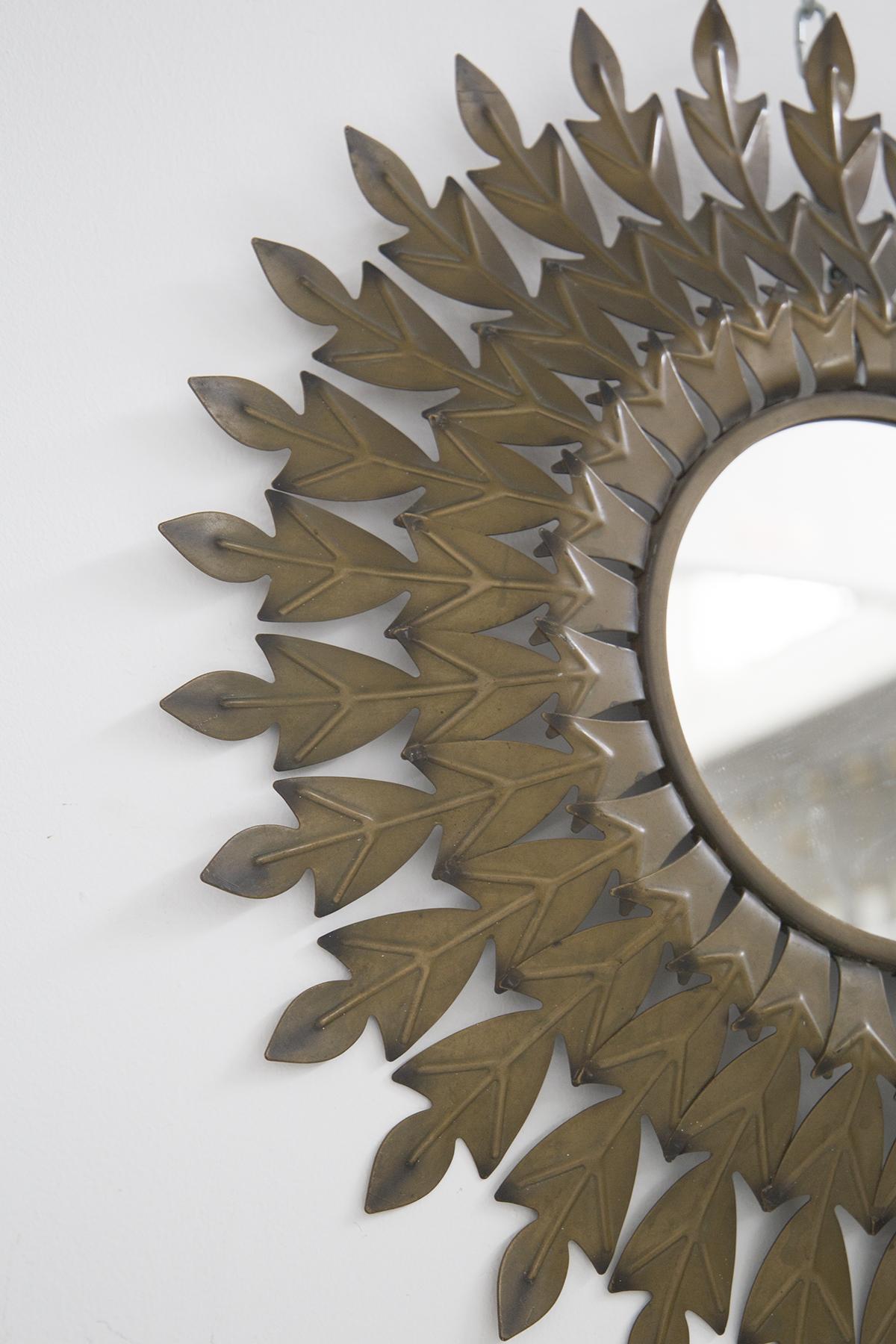 Gorgeous brass sunburst mirror designed in the middle of the last century, 1960s, of Fine Italian manufacture.
The mirror has a round shape and is framed by a very fine and elegant patina brass frame.
The sunburst is composed of a series of three