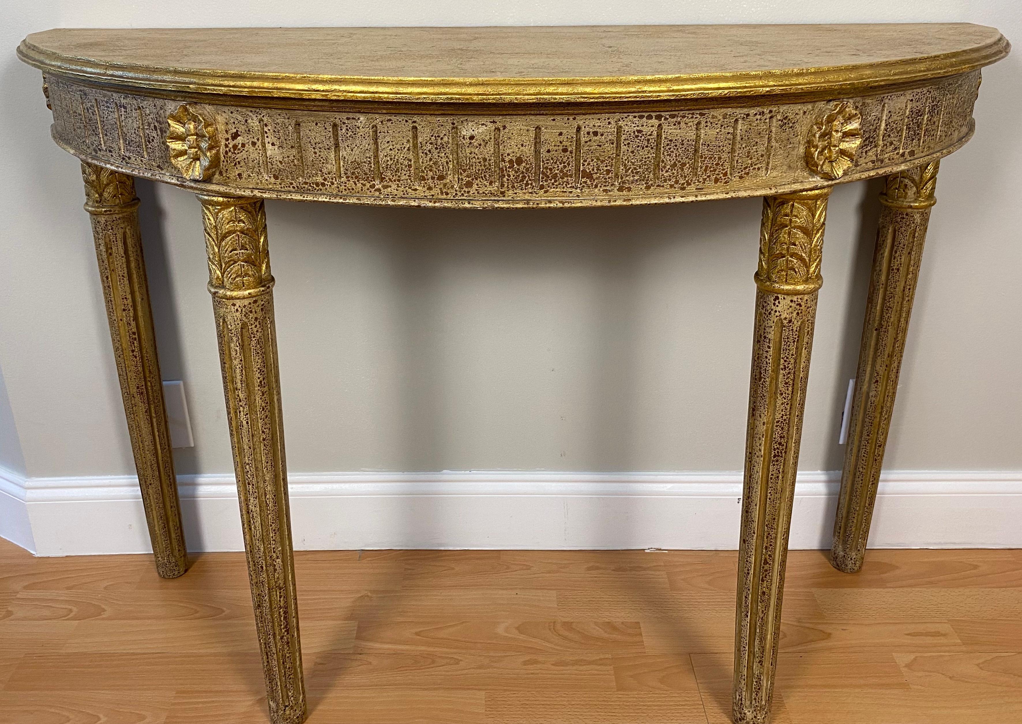 A good quality demi-lune or half moon console table from the early 20th century. This table is half-moon shaped with beautiful hand-carved details of leaves and flowers on its apron. 

French stylized design with a Hollywood Regency finish. It is