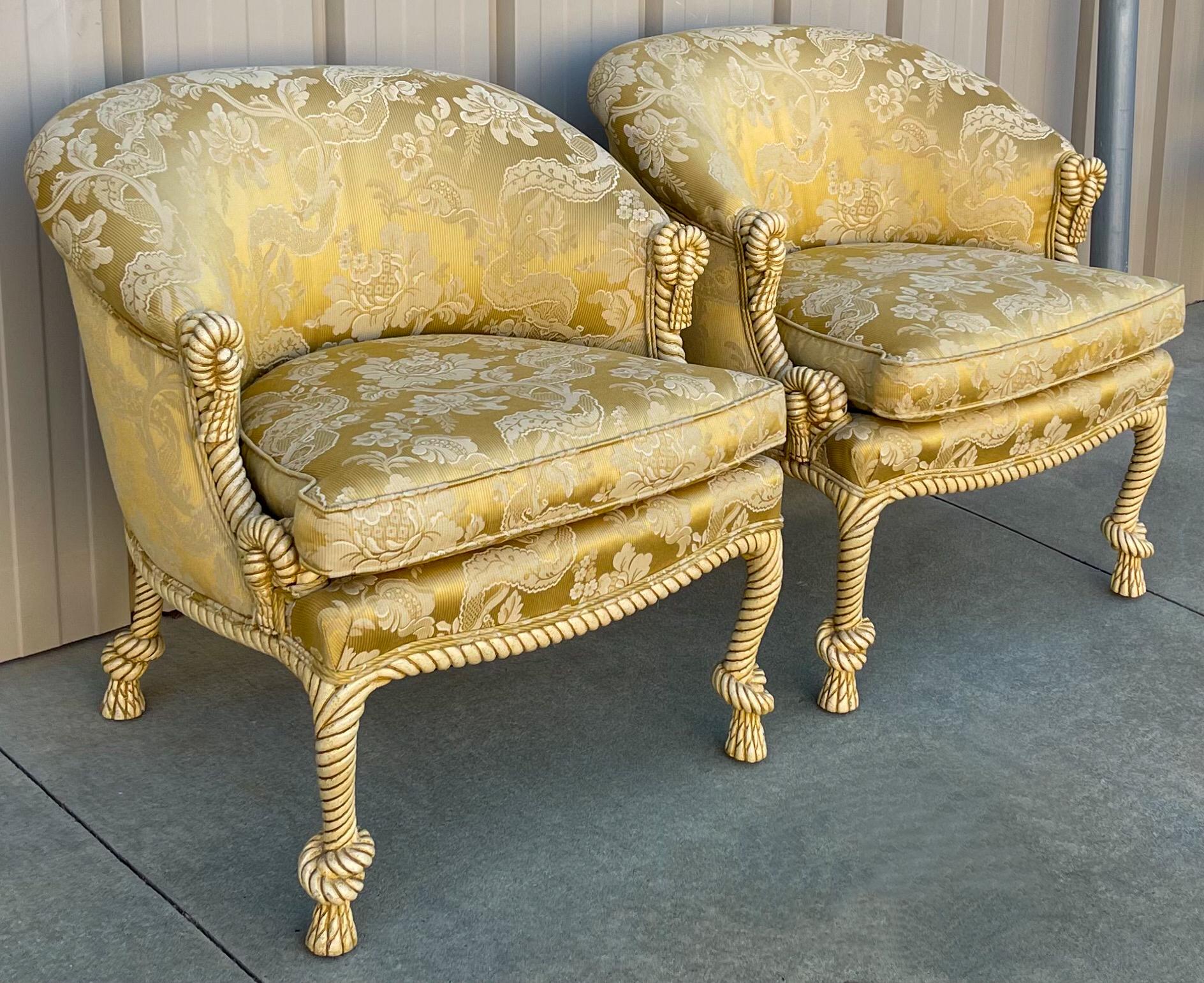 I love these! This is a pair of Hollywood Regency Era carved rope, tassel and knot chairs. The yellow/golden damask fabric is vintage but in very good condition as is the frame. They are unmarked.