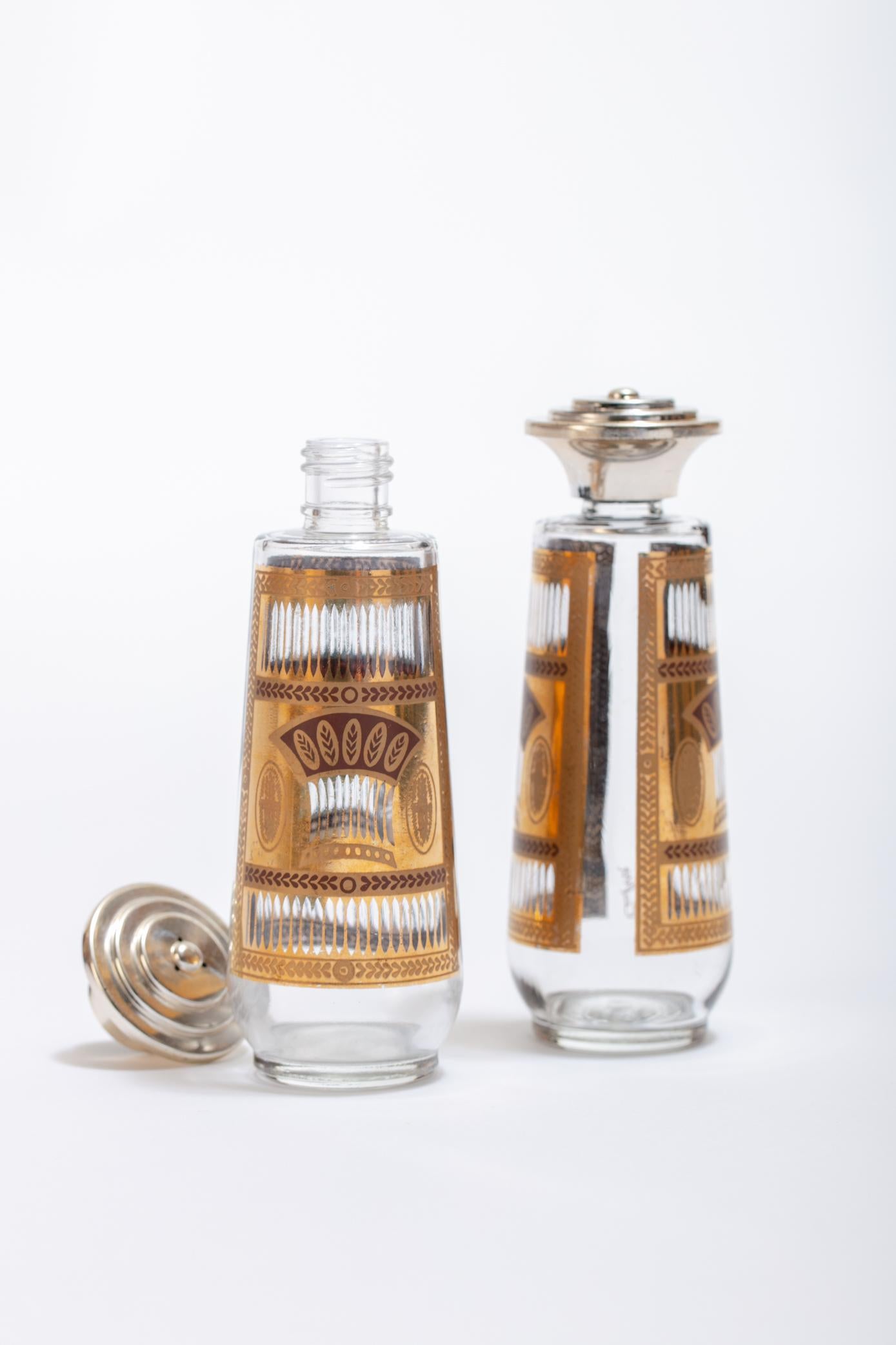 Culver Ltd Mid-Century Modern, atomic style glass salt and pepper shakers featuring 22-karat gold Golden Wheat pattern on the glass. The lids are made of chrome-toned painted plastic and are in good vintage condition. Want to see more beautiful