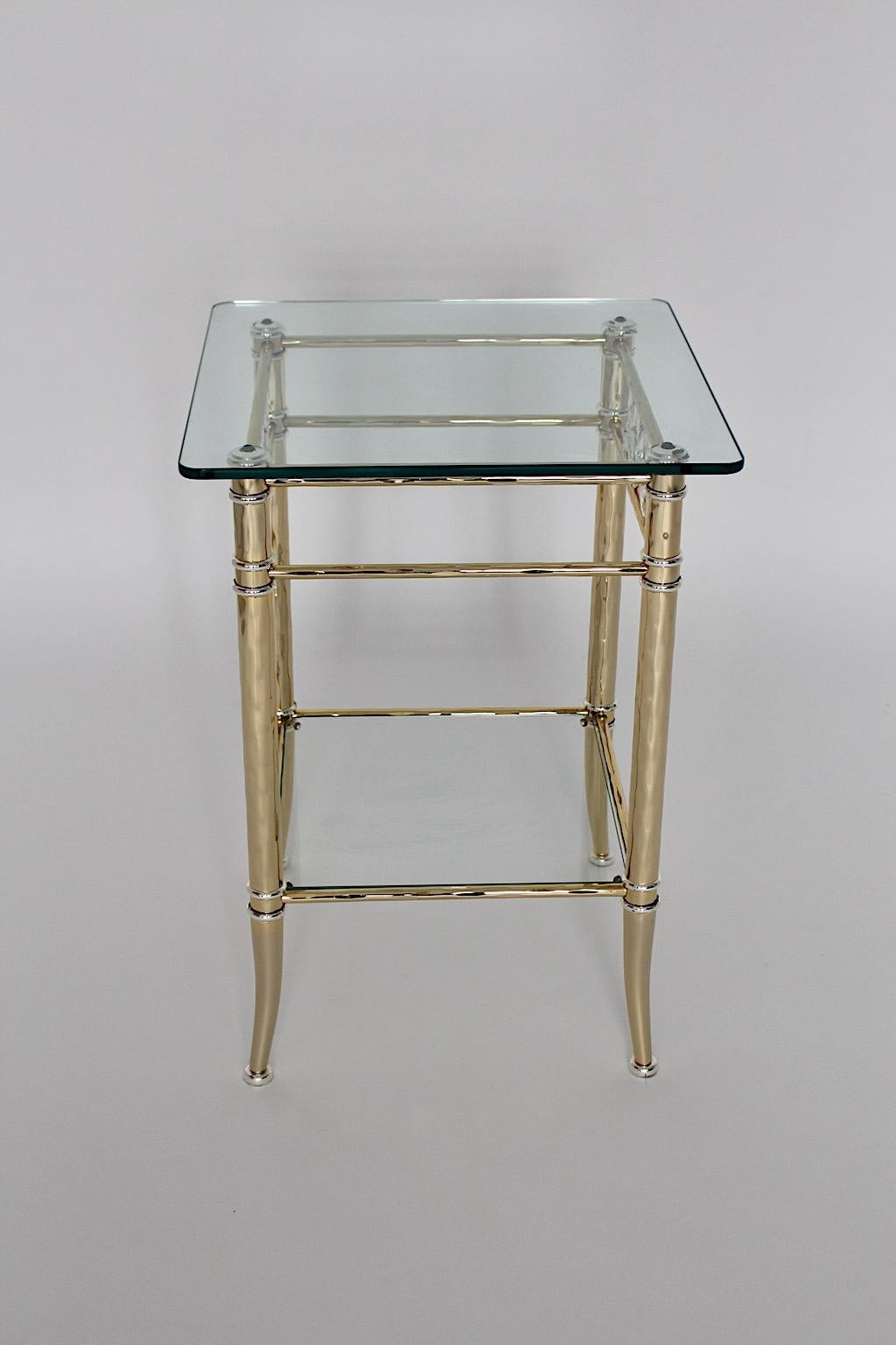 Hollywood Regency Style side table from gilt and silvered metal with clear glass plates flower decor Style Maison Bagues 1970s France.
A fantastic freestanding side table with two tiers from clear glass and slightly curved legs from gilt and