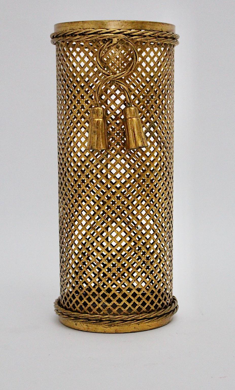 A Hollywood Regency style vintage gilded umbrella stand, which was made in Florence, Italy, circa 1950 by Li Puma Firenze. The amazing Mid-Century Modern gilded umbrella stand is a perforated metal stand, which shows metalwork pattern, tassel and