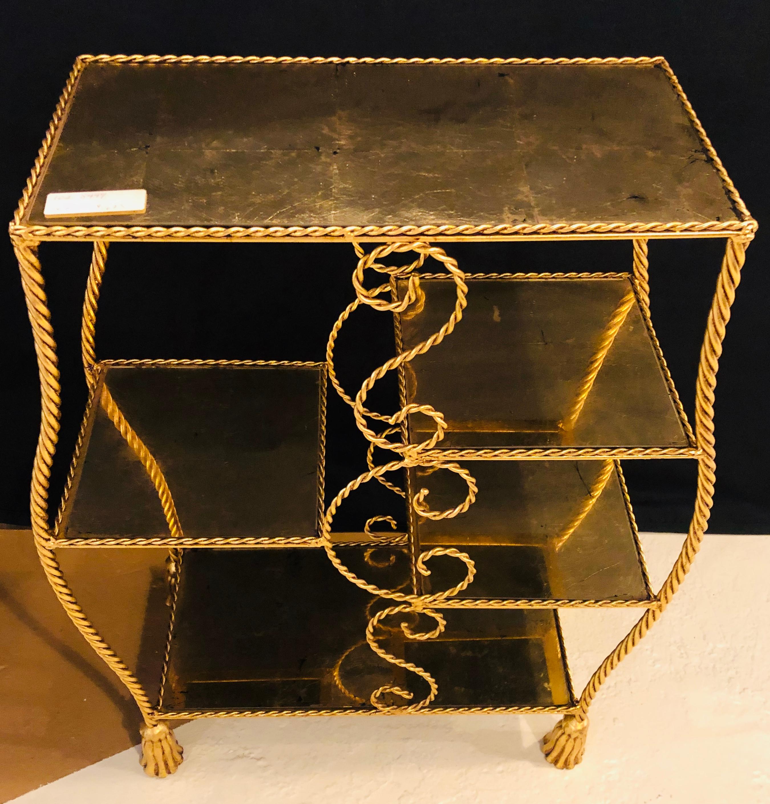 Hollywood Regency style gilt-brass étagère of beautiful twisted-rope form, glass shelves joint by scroll-like decoration, raised on tassel feet. By Jansen.