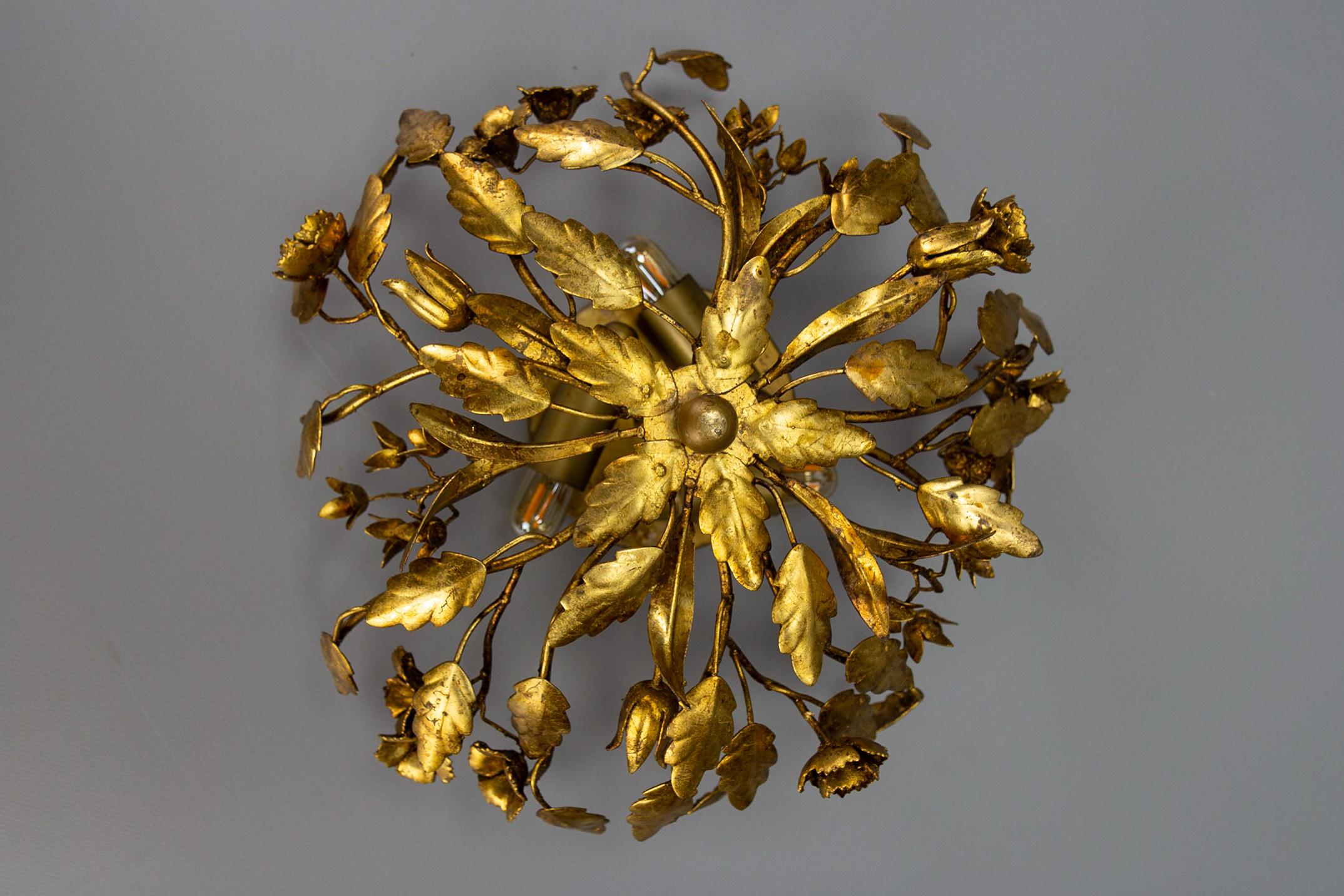 Hollywood Regency style gilt metal floral flush mount or ceiling light, Germany, circa the 1970s.
This adorable Hollywood Regency-style gilt metal floral flush mount or ceiling light is adorned with beautifully shaped leaves and flowers.
Three