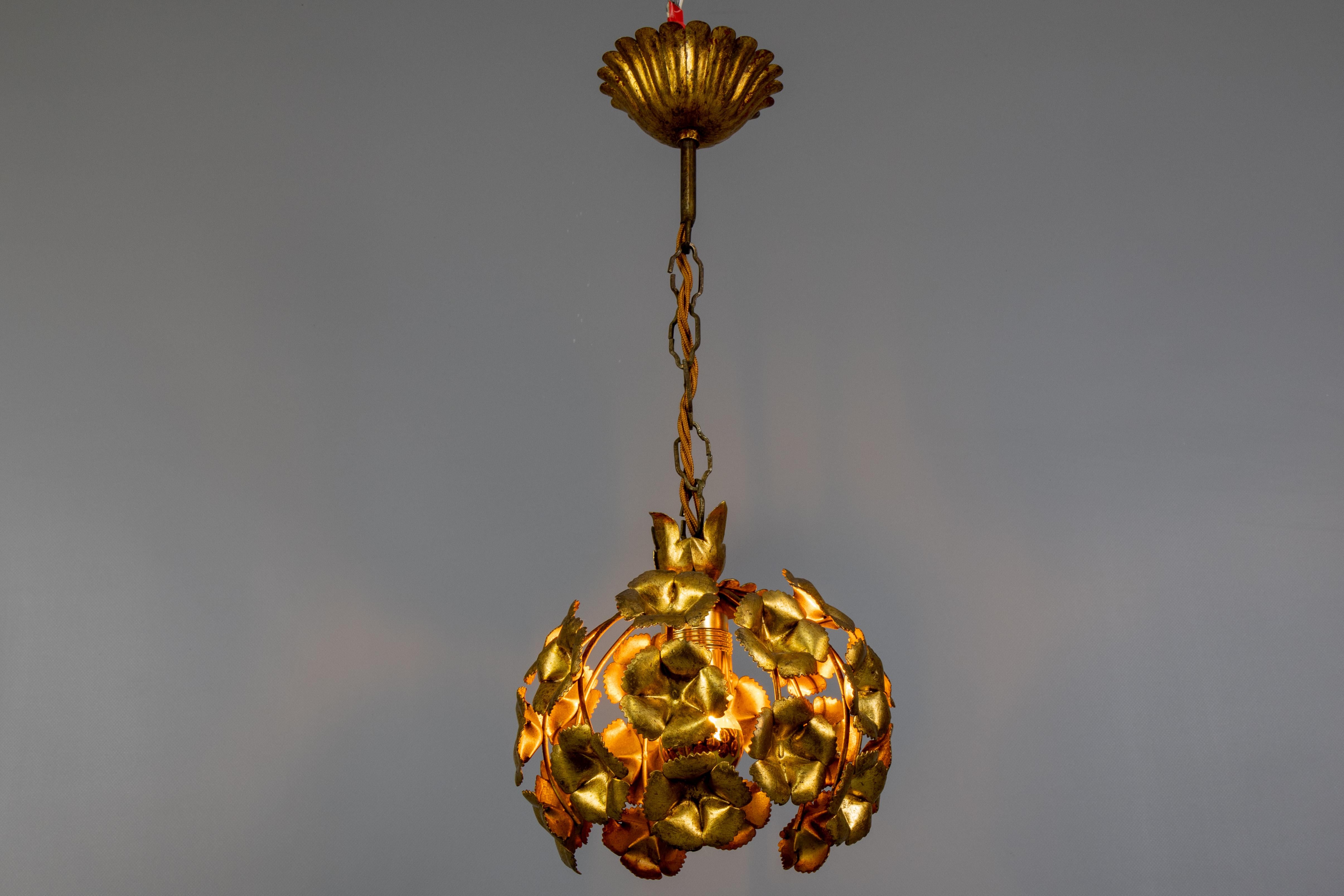 Compatto ma di grande effetto, questo ciondolo floreale in metallo dorato incarna il glamour e l'eleganza scultorea dell'epoca Regency di Hollywood.

Una splendida lampada a sospensione francese in metallo dorato degli anni '70, progettata in stile
