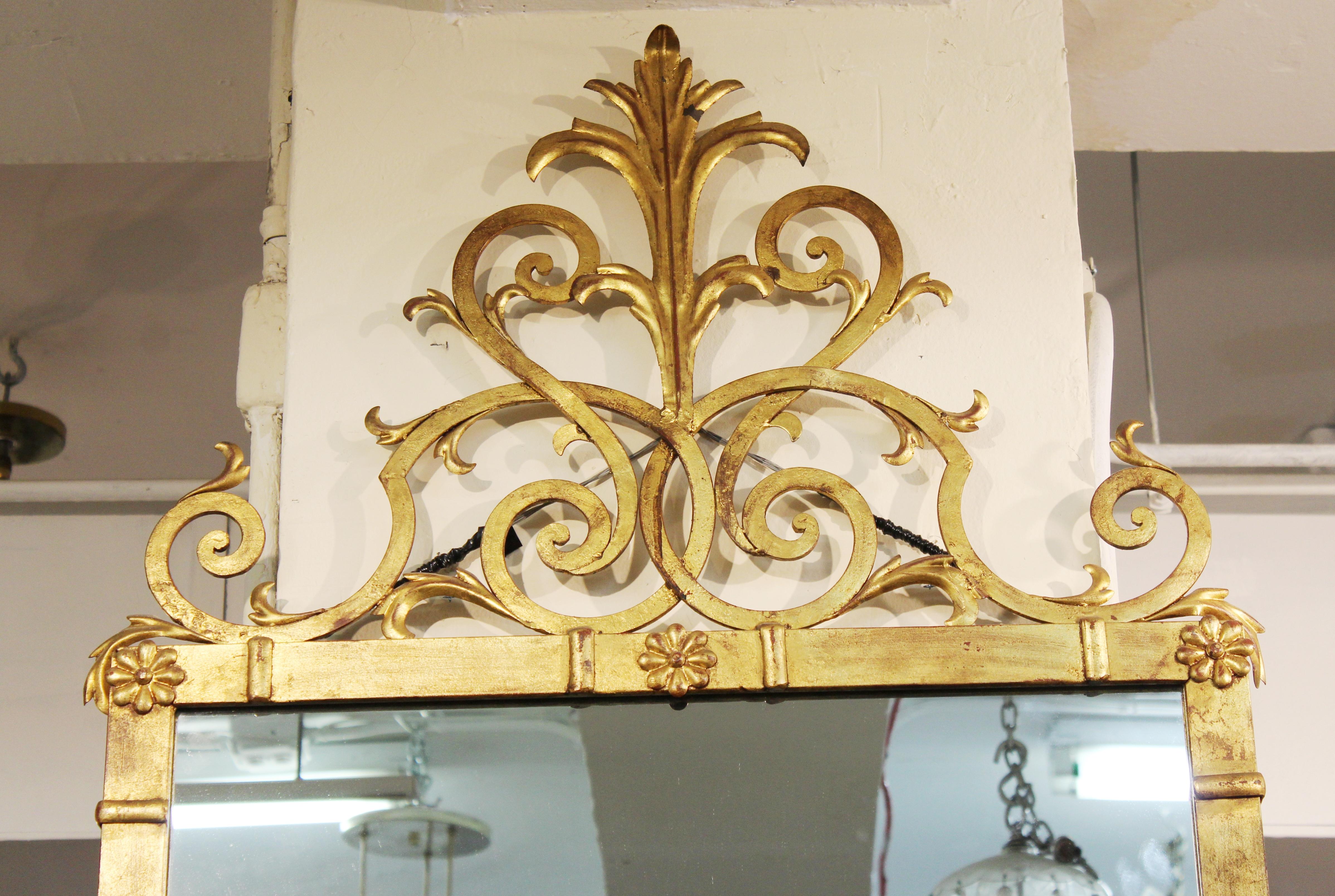 Hollywood Regency style wall mirror in gilt metal with scrollwork crest
