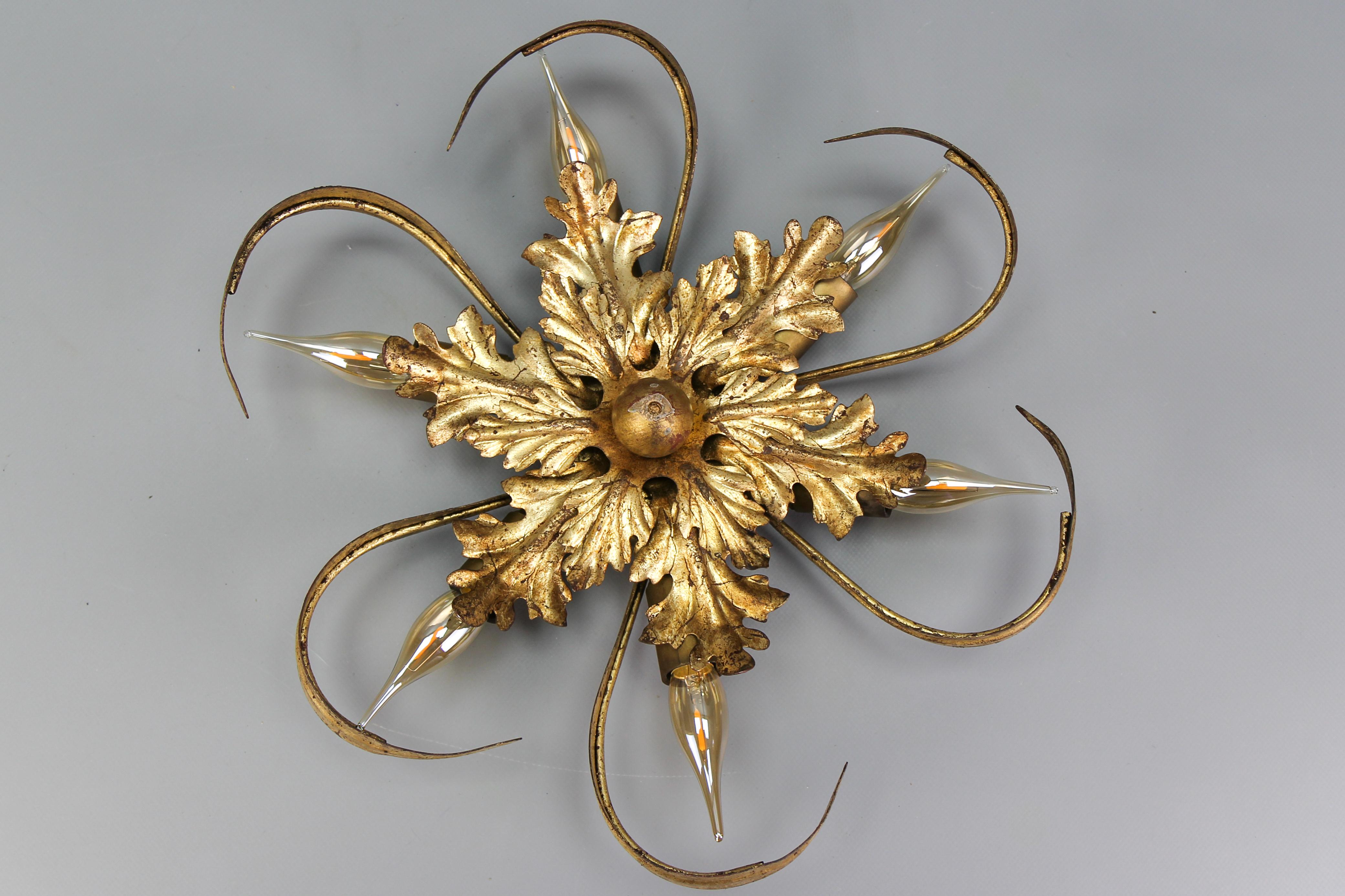 Hollywood Regency style gilt metal six-light oak leaf flush mount or wall light from the 1970s, Italy. 
This adorable sunburst-shaped ceiling lamp or wall sconce features six lights with sockets for E14-size light bulbs. 
The light shining through