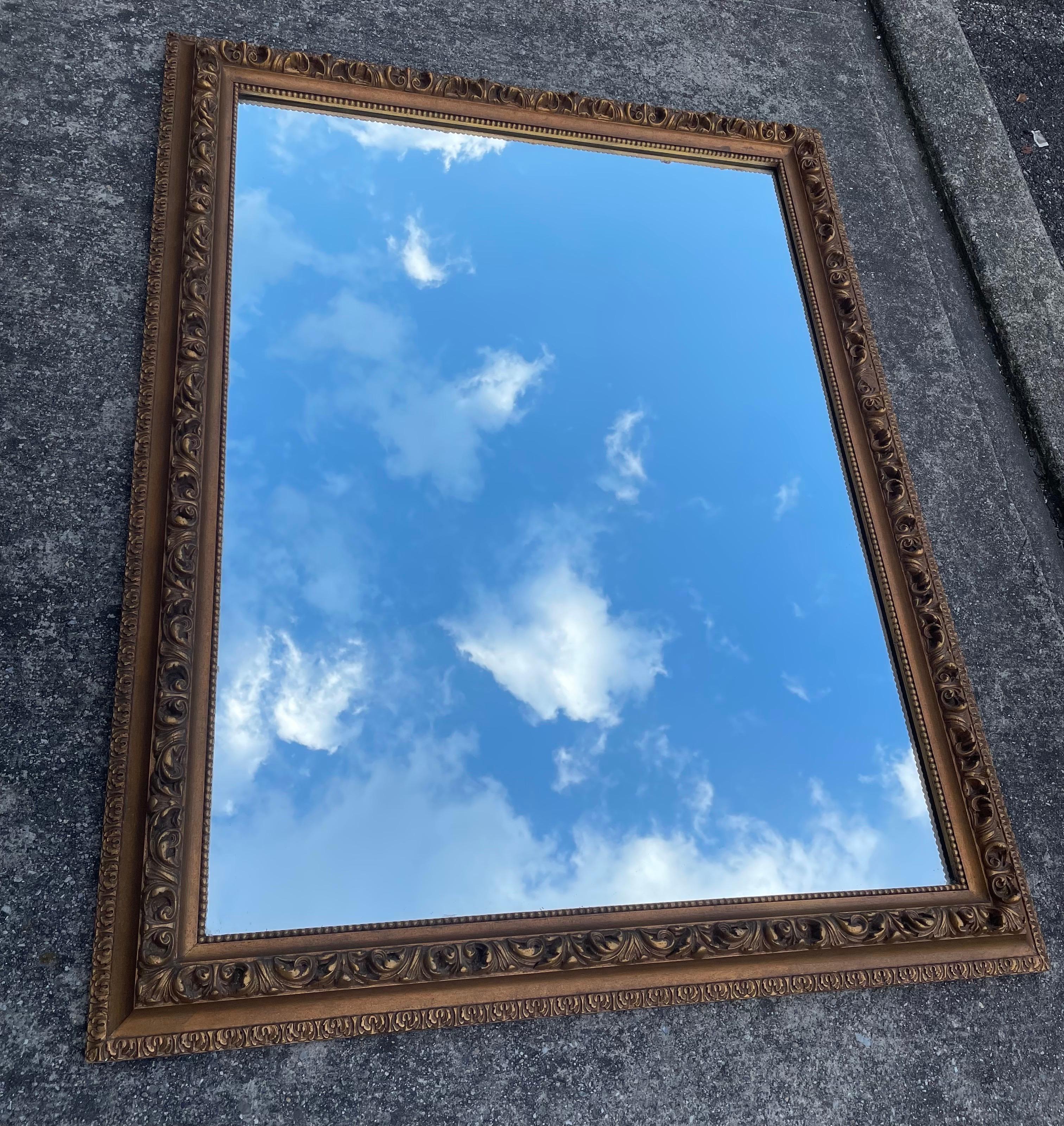 Beautiful large Hollywood Regency gilt wood gold mirror, raised floral leaf pattern, 1950's.