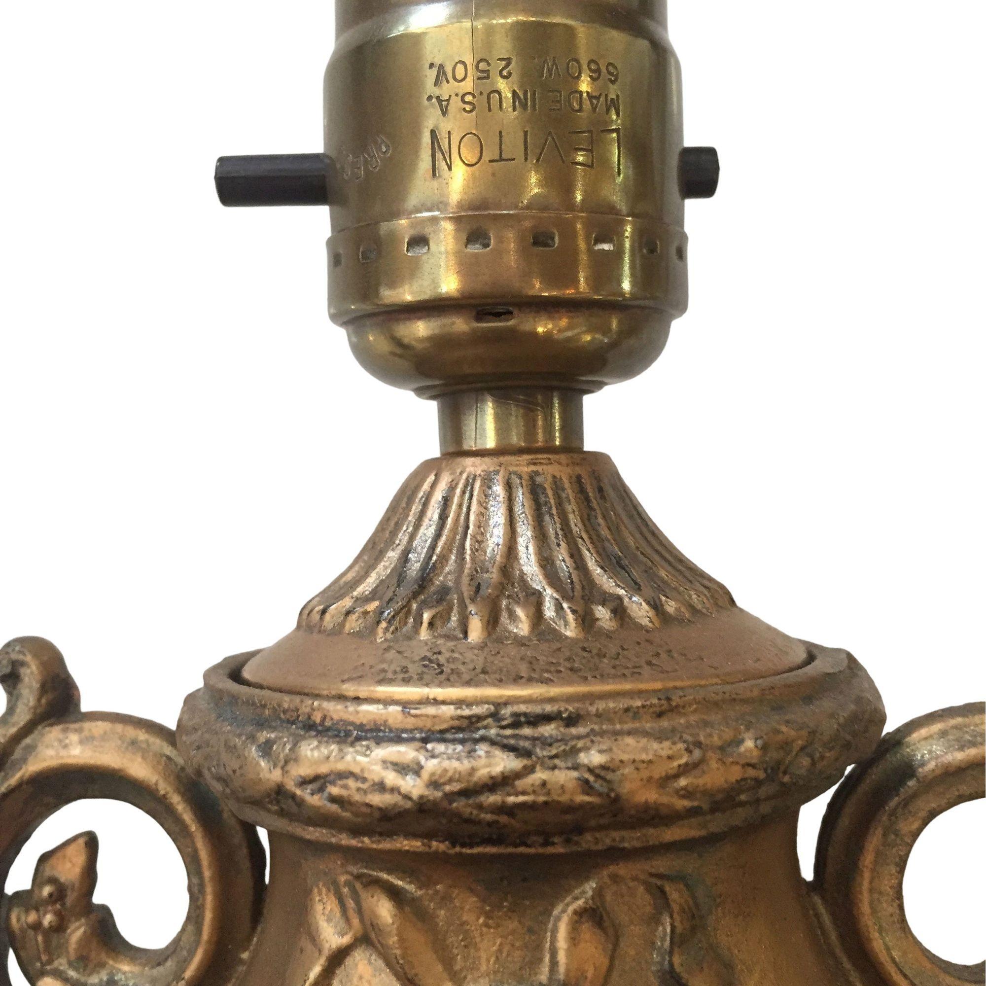 Urnenlampe im Hollywood-Regency-Stil aus goldfarbenem Gusseisen auf grünem Marmorsockel.

Maße: 13