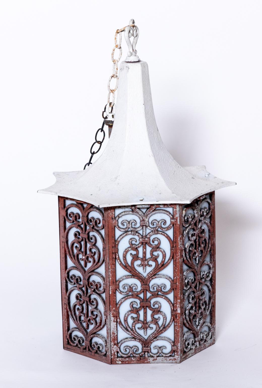 Circa mid-20th century Hollywood Regency style octagonal lantern. Each side features frosted glass panels behind an intricate c-scroll and heart shape metalwork designs. Each piece comes electrified with 12.00 Inch chain and a later ceiling cap.