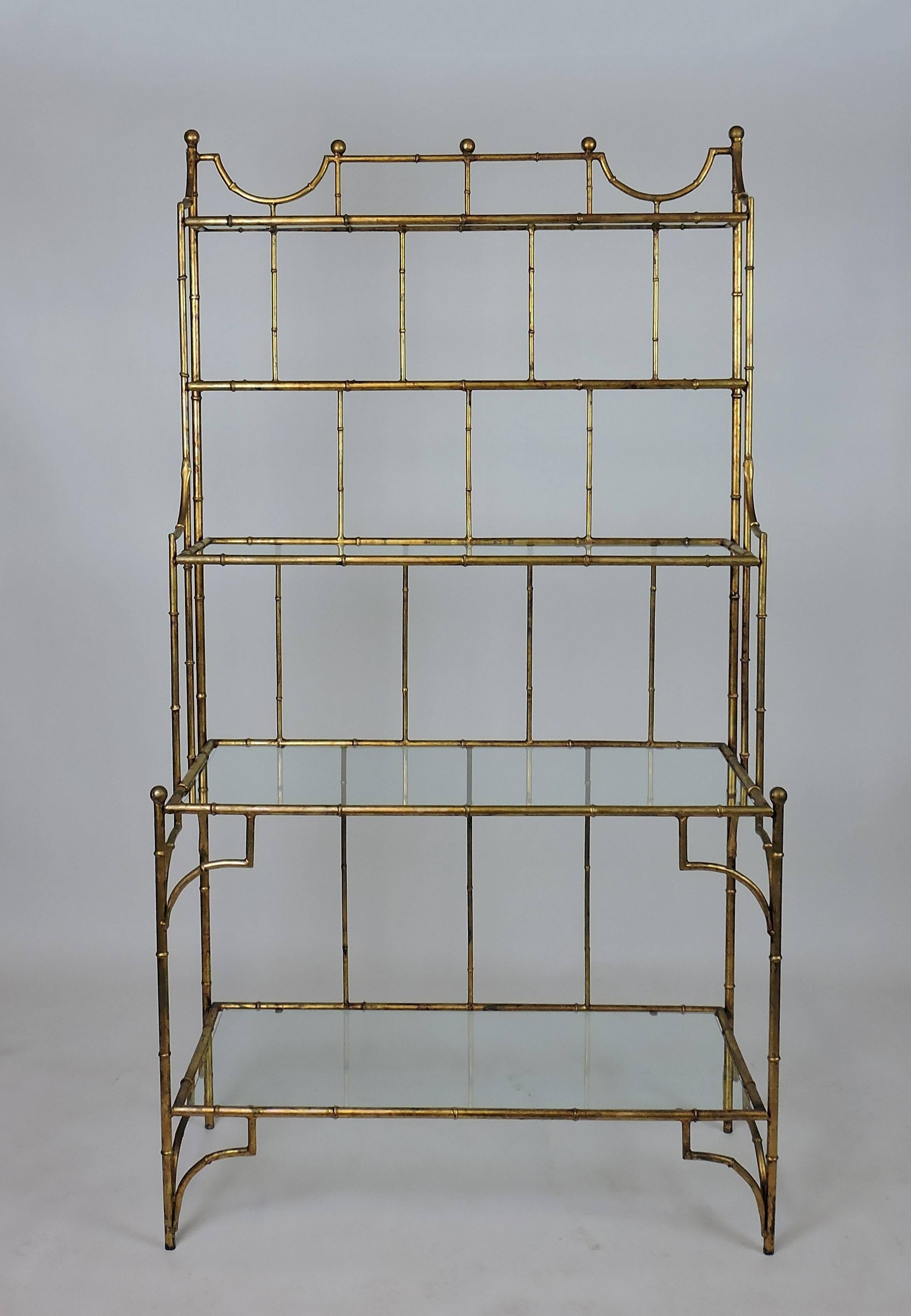 Striking faux bamboo iron and glass étagère. This high quality étagère has a beautiful antiqued gilt finish and five glass shelves of varying depth.
The glass shelves are removable for transporting.