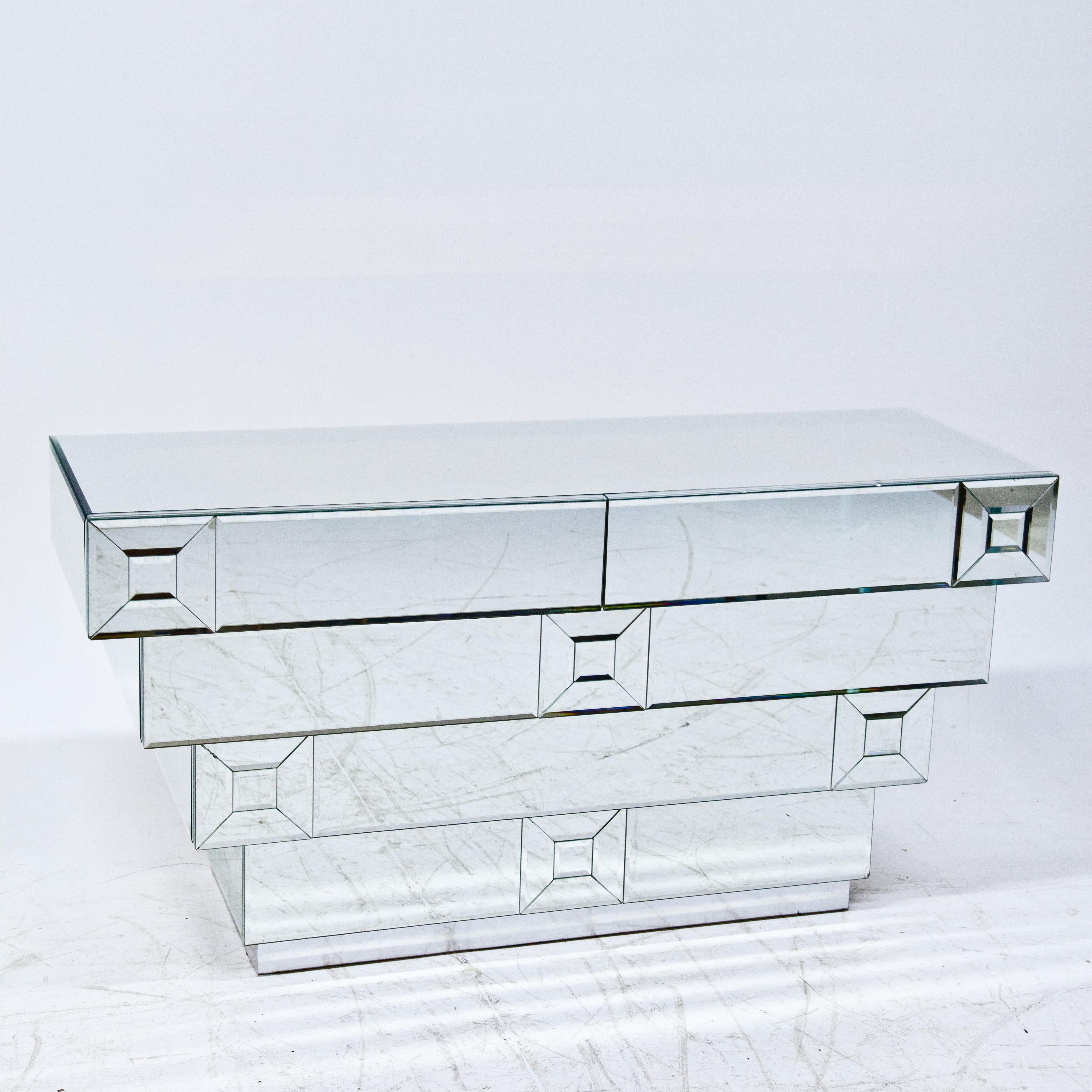 Chest of Drawers in a Hollywood Regency style with 
five drawers and a completely mirrored body. 
The individual mirror panes are elegantly faceted at the edges.