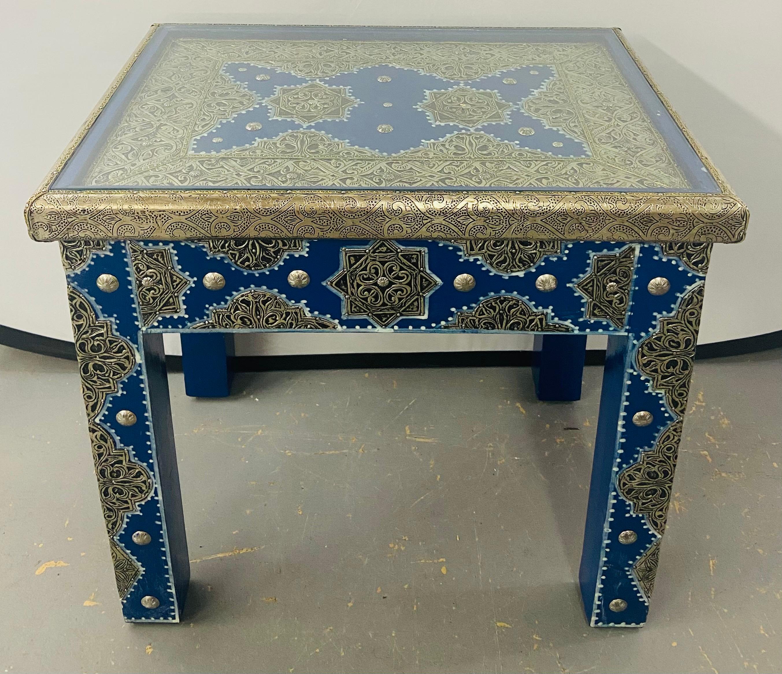 An exceptional pair of Hollywood Regency style Moroccan white brass inlaid wood end or side tables in blue Majorelle. Designed by master artisans, handcrafted using fine white brass and hand painted in blue Majorelle inspired by the legendary Yves
