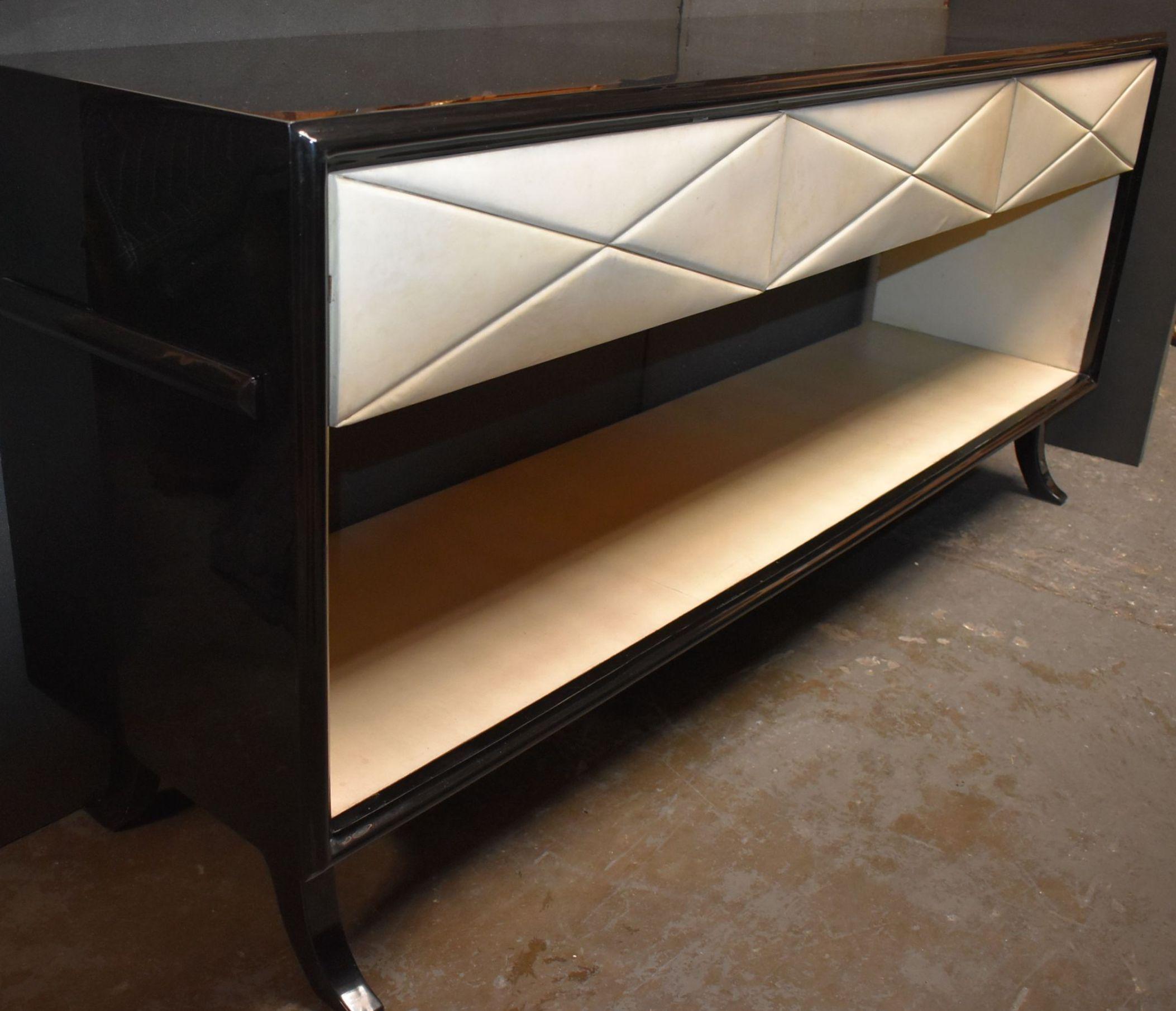 Three pillows style drawers with open shelf sideboard, console (The interior opening show parchment details) cover with natural goatskin and resin over black painted finish. Also there is pullout / pull-out tray on each side.

Please note: Small