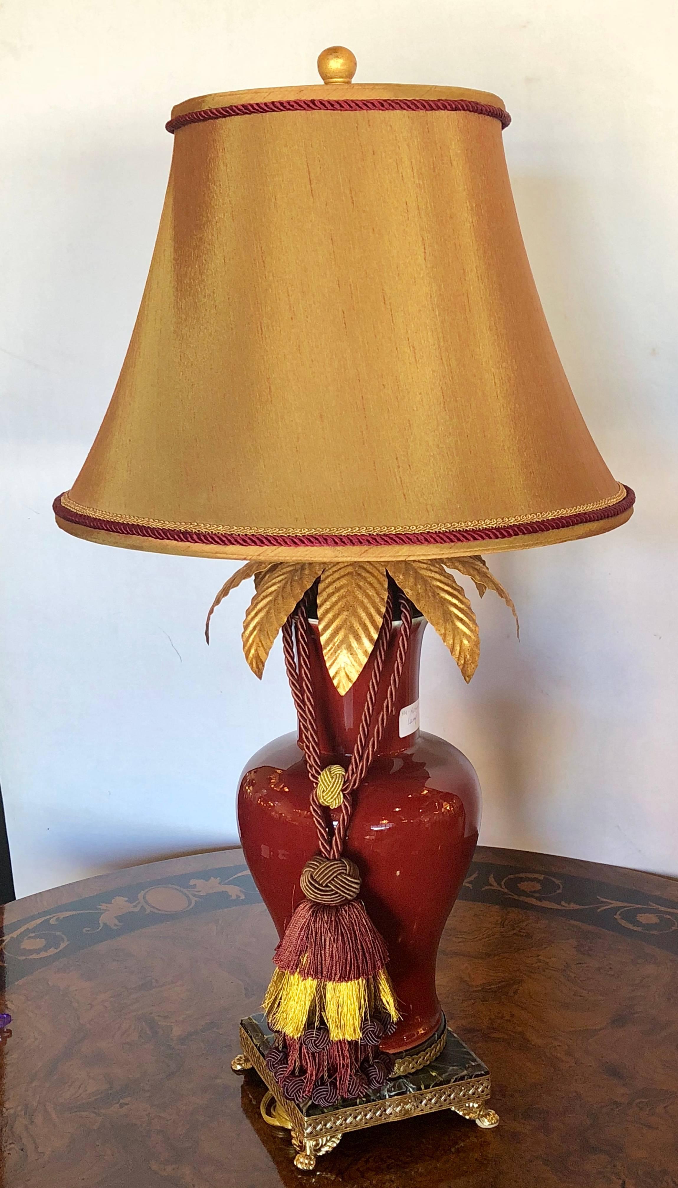Ruby red Celedon single large table lamp by F. Cooper (signed). Vase measures 18 inches high. On claw feet with lace designed apron this table lamp brings the Hollywood Regency style and glamour to its peak. The red celedon porcelain vase now