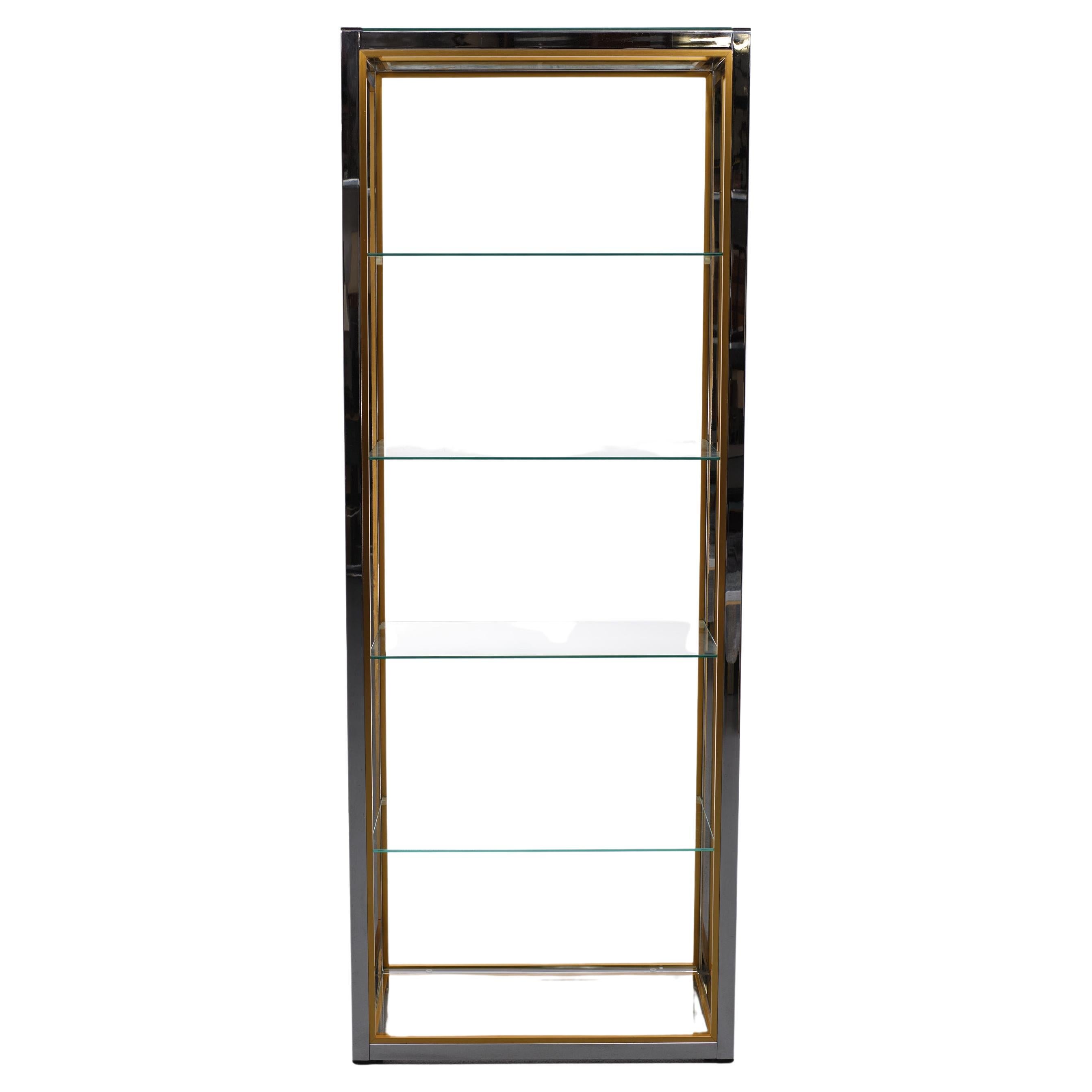 Beautiful vitrine, manufactured by Renato Zevi in his classic chrome and gold style, is an excellent example of the Hollywood Regency opulence of the 1970s. A chrome frame with gold aluminium details supports a four floating glass shelves, and is