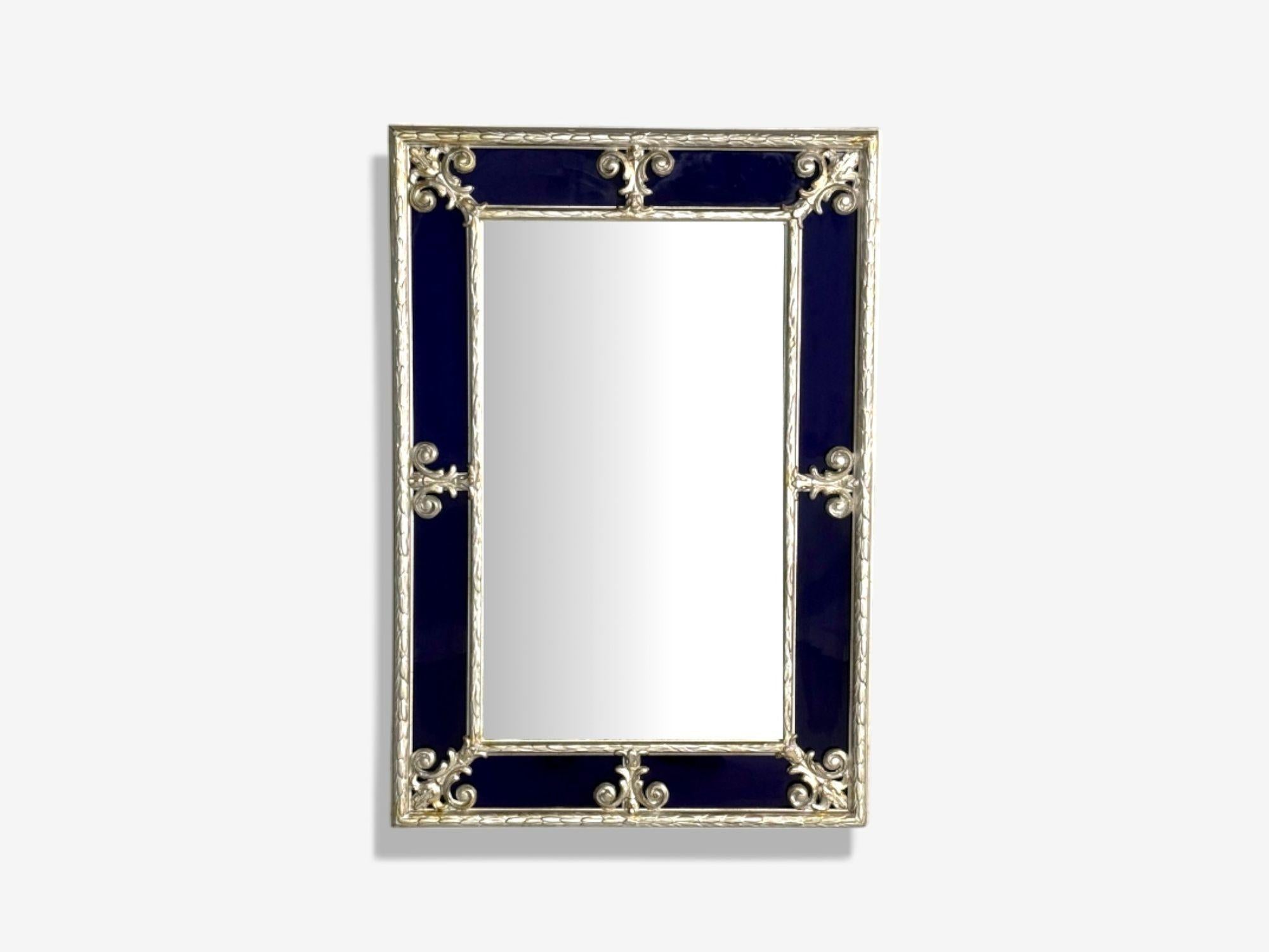 Petit miroir de style Hollywood Regency, verre bleu cobalt, feuille d'argent, années 1980

Ce magnifique miroir bleu cobalt est orné d'un motif Fleur de lys en argent doré, entourant un double cadre sculpté en argent doré. La composition encadre